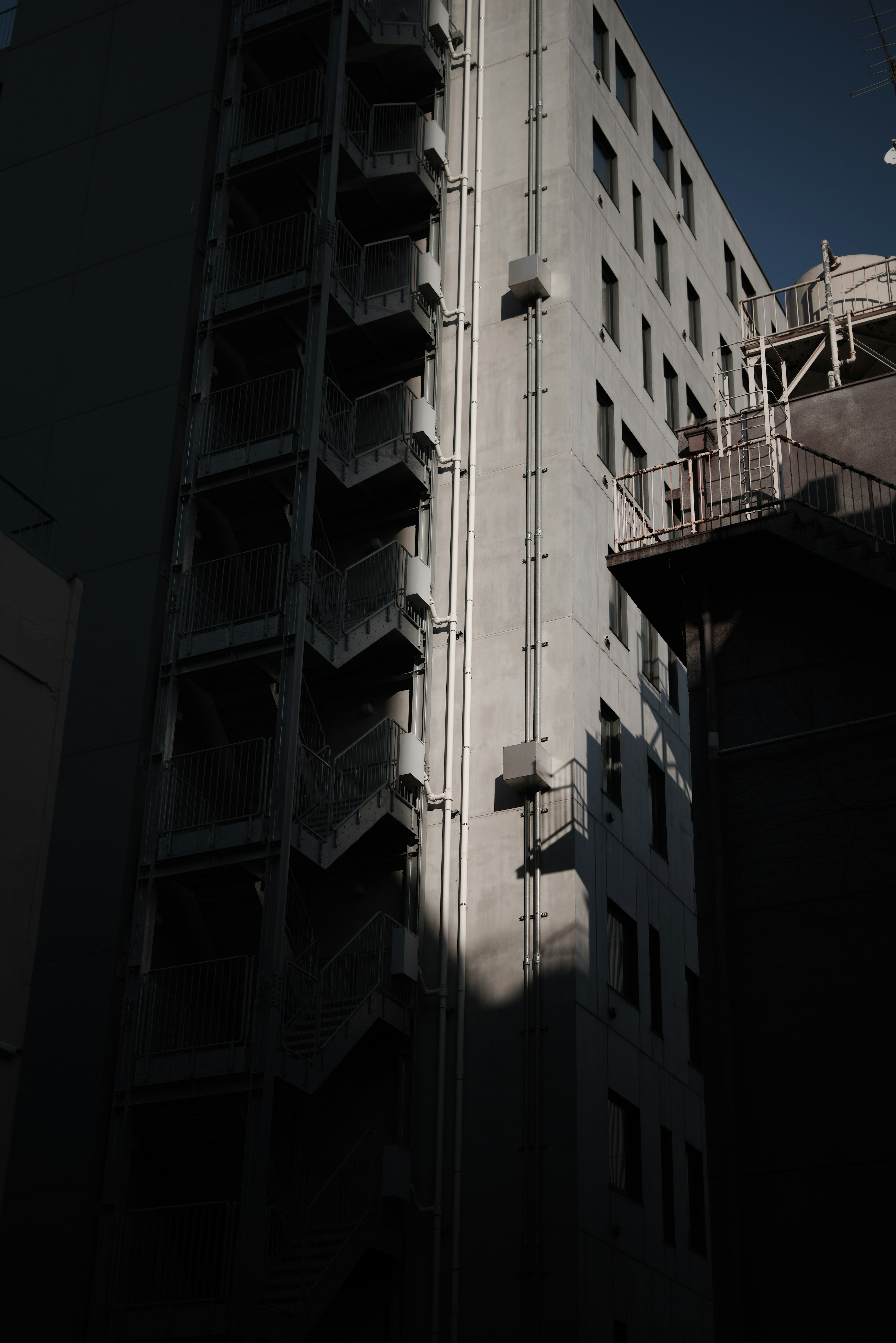 暗い背景の中にある建物の外壁と階段