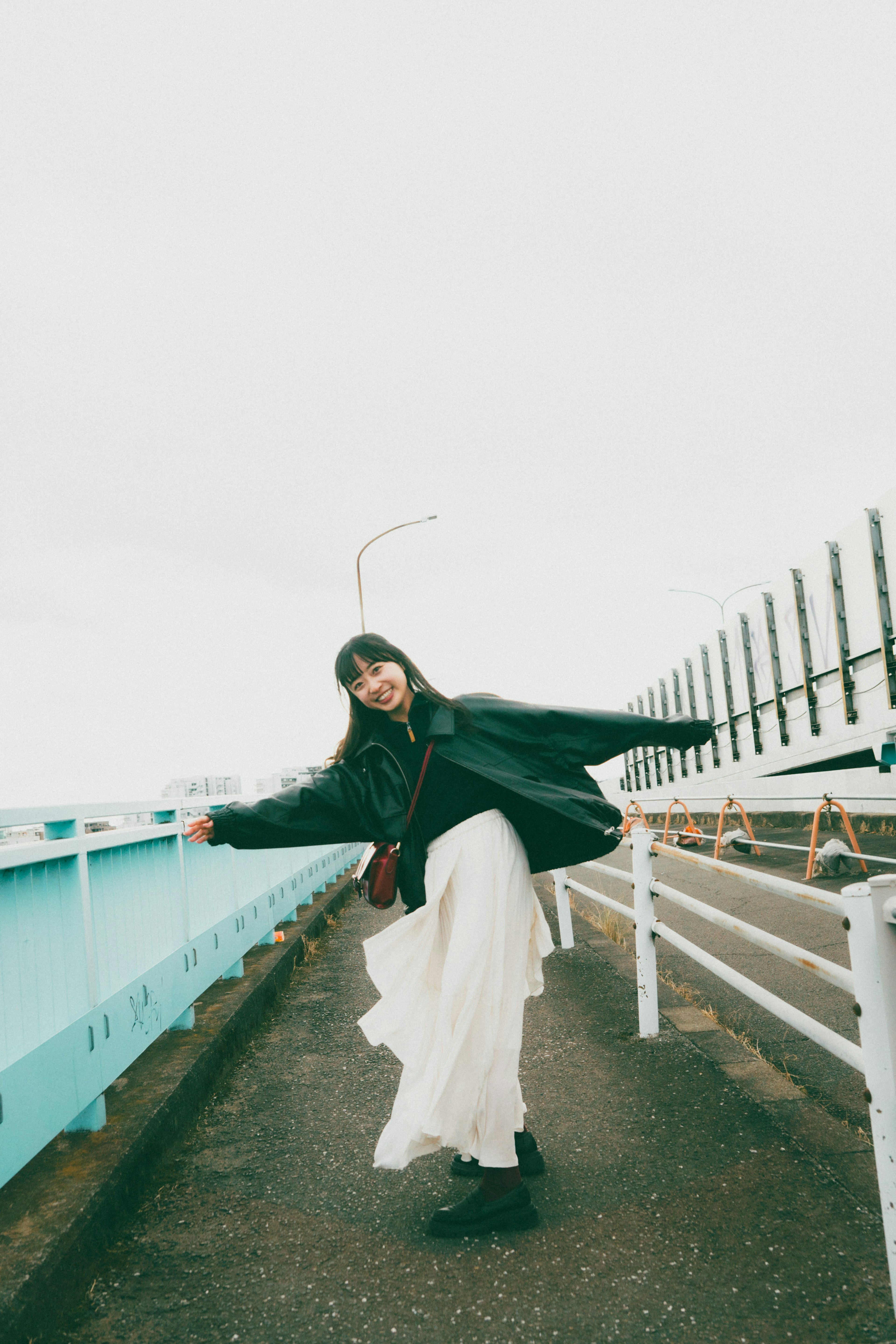 A woman in a white dress posing on a bridge