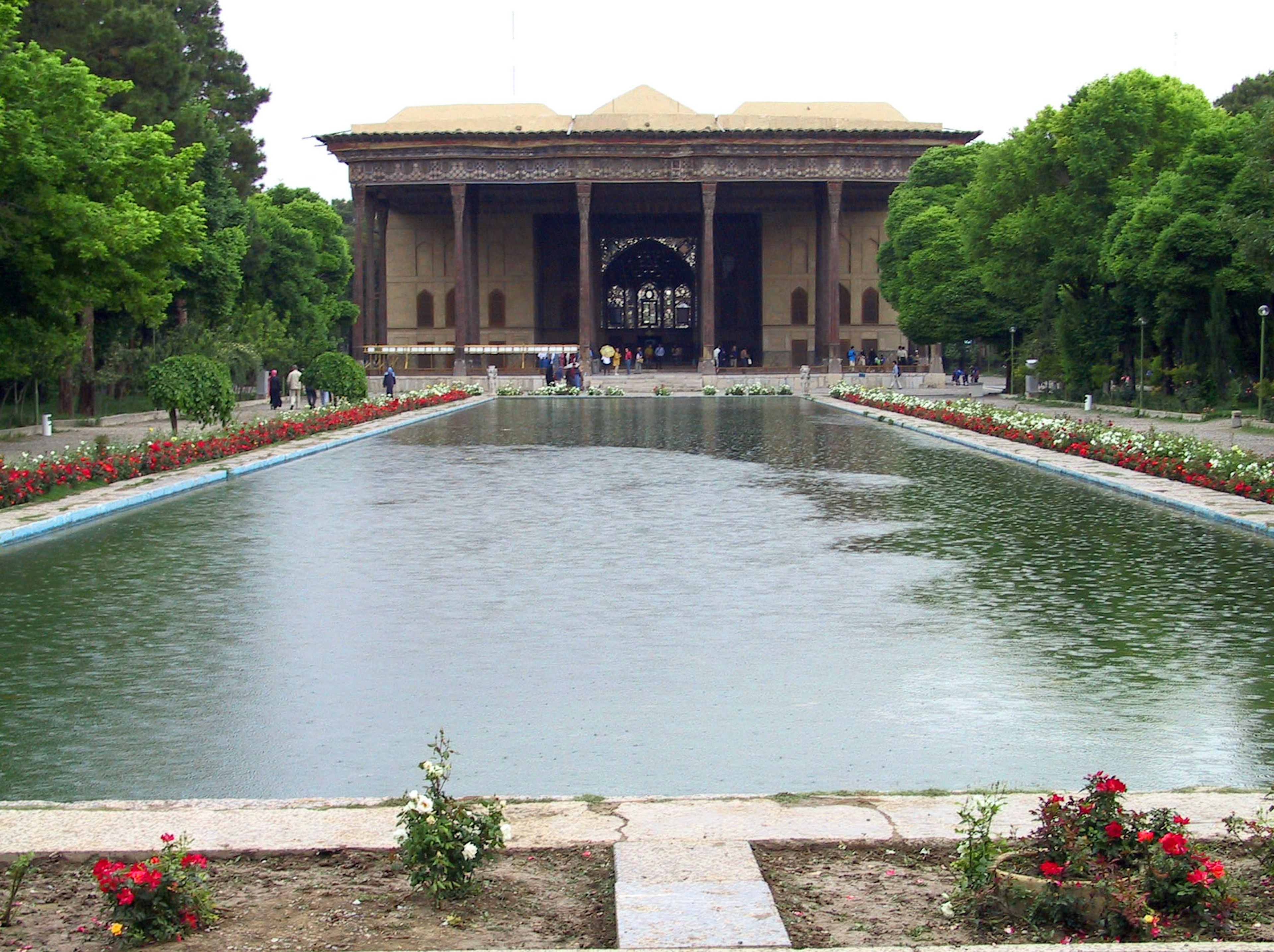 Vista escénica de un estanque de jardín con un edificio histórico