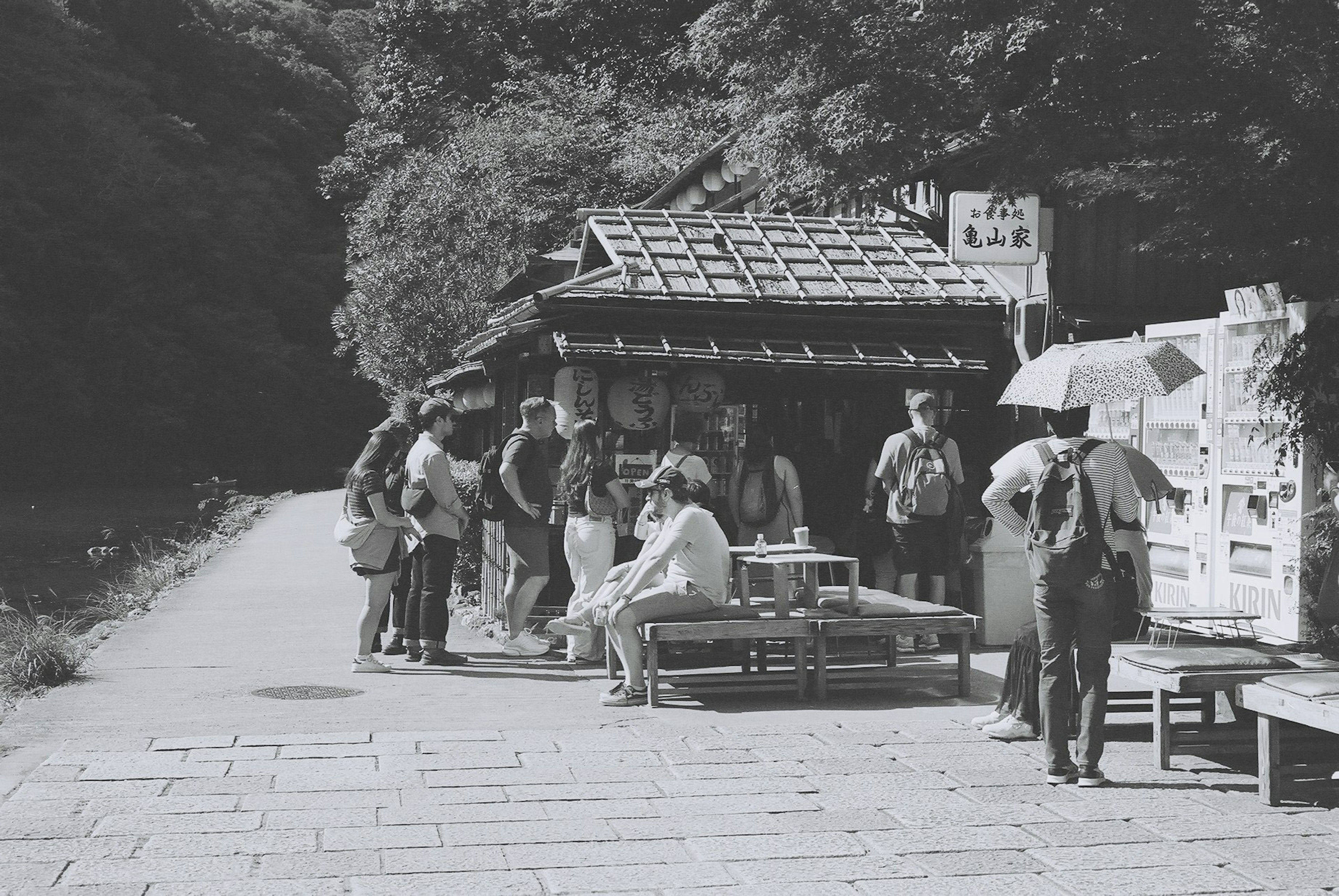 Scene of a traditional street market with people gathered around stalls and tables