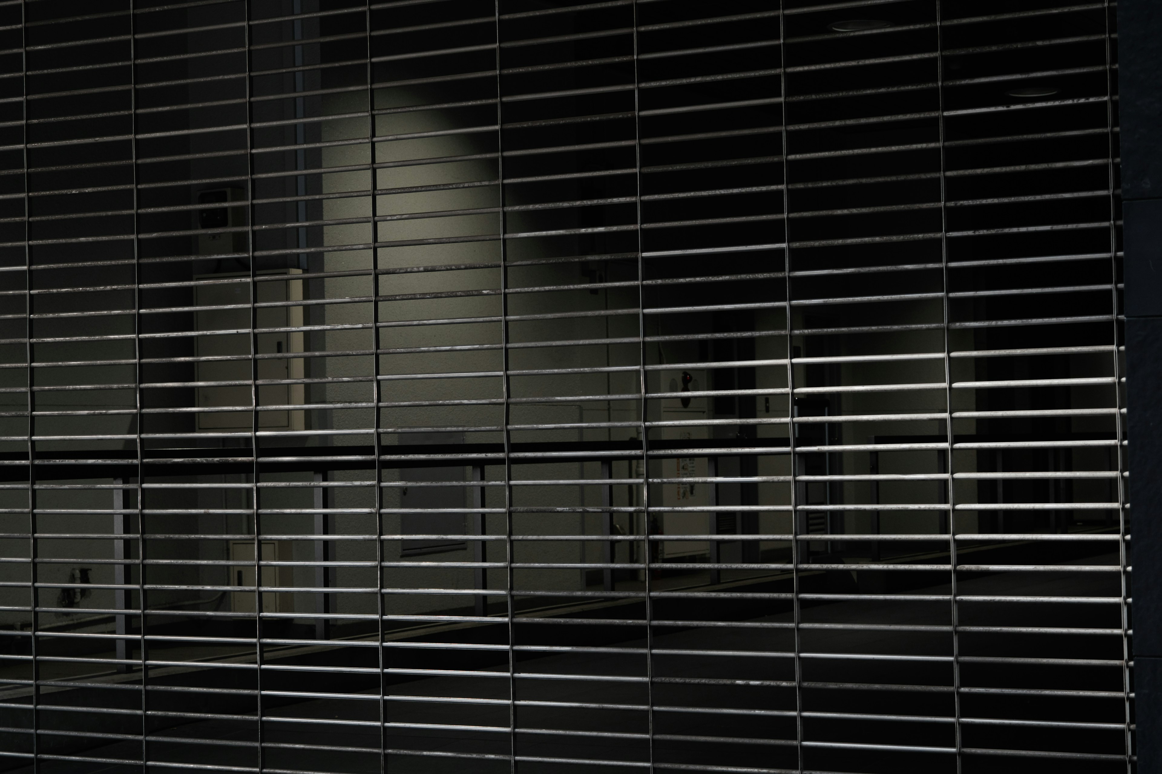 Metallic shutter with a grid pattern against a black background