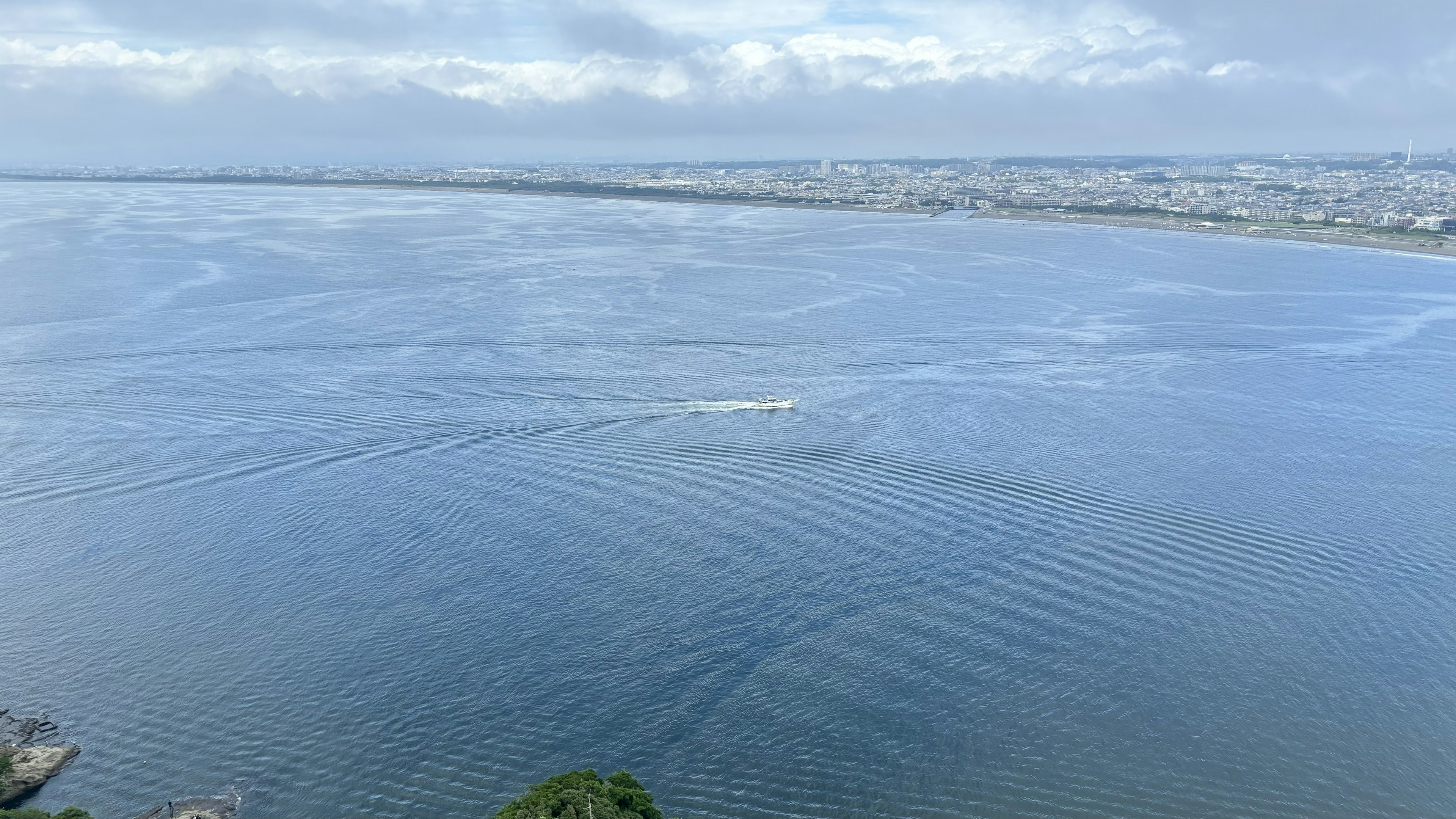 Blue water surface of the sea with distant cityscape