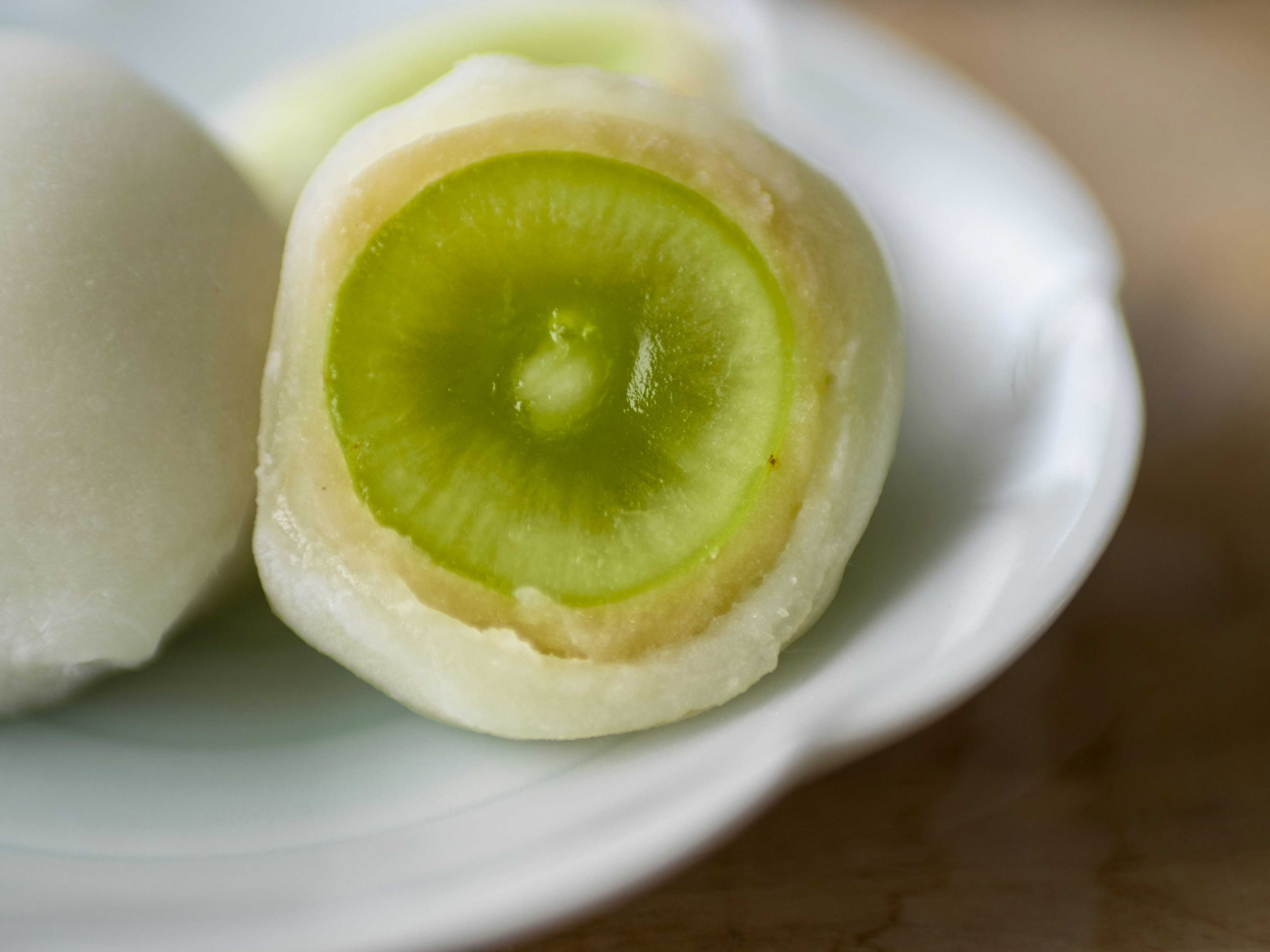 Un fruit vert enfermé dans du mochi blanc