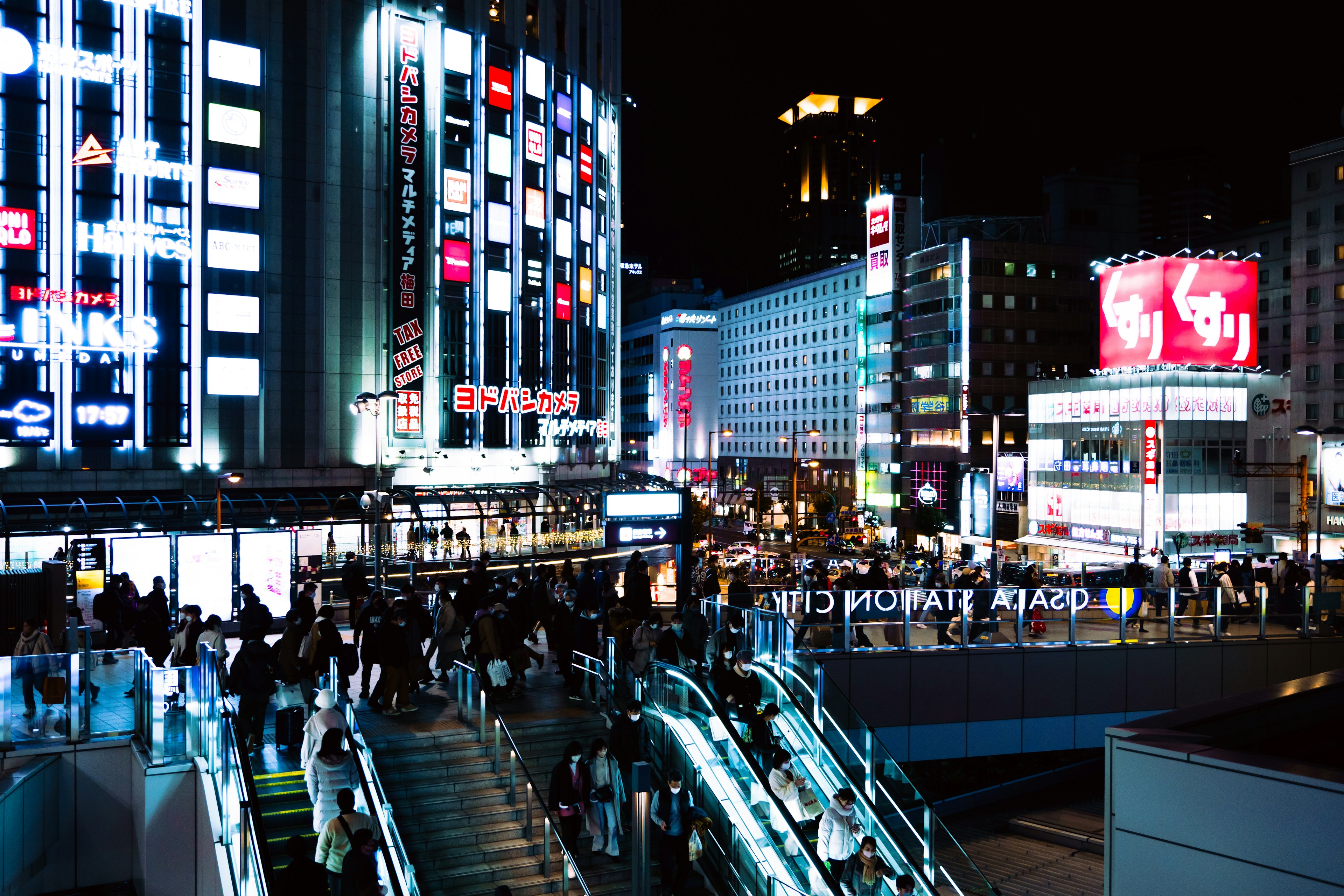 Vibrant urban scene at night with crowds and neon signs