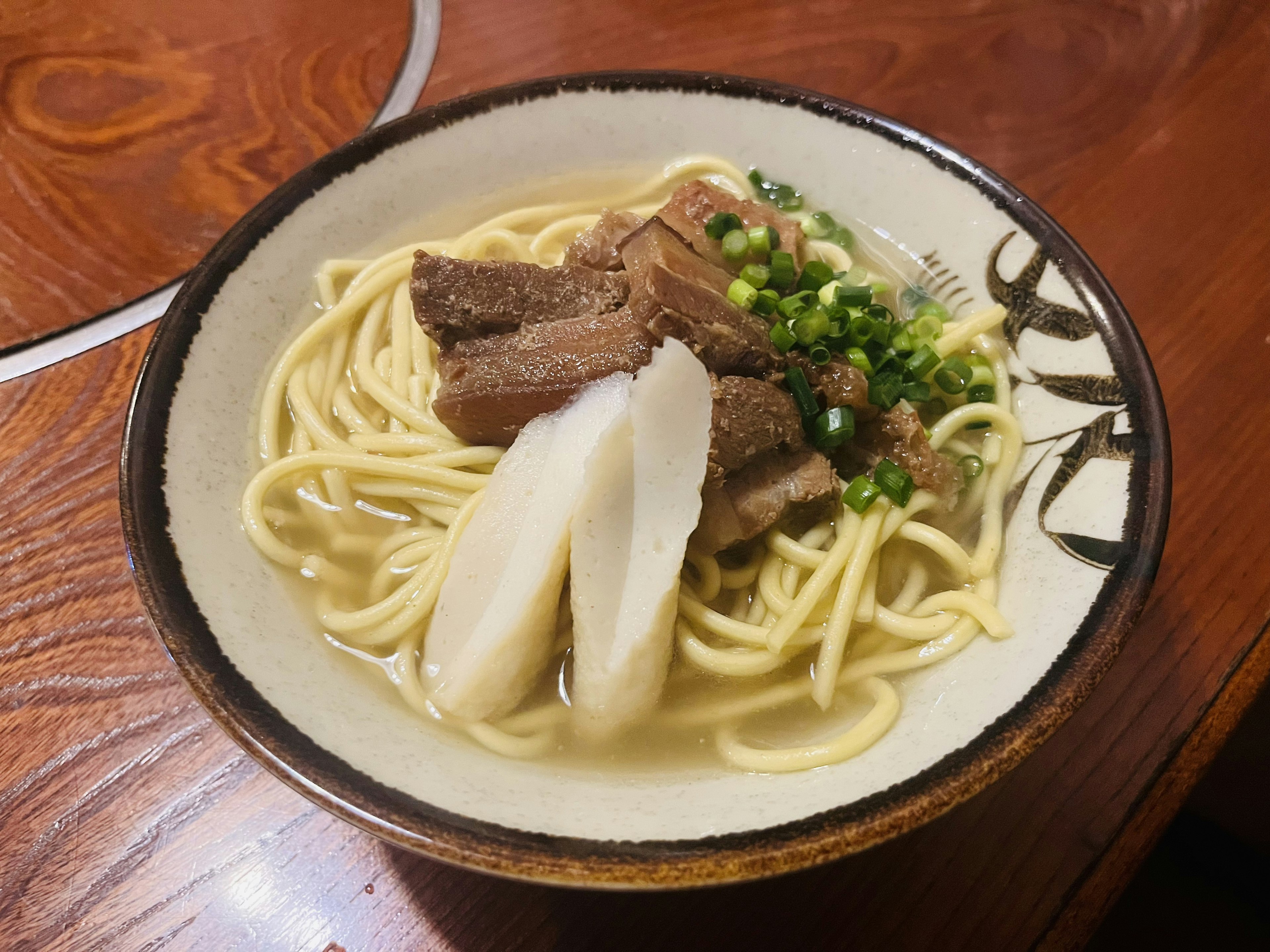 Semangkuk ramen hangat yang ditambahkan irisan daging sapi dan bawang hijau