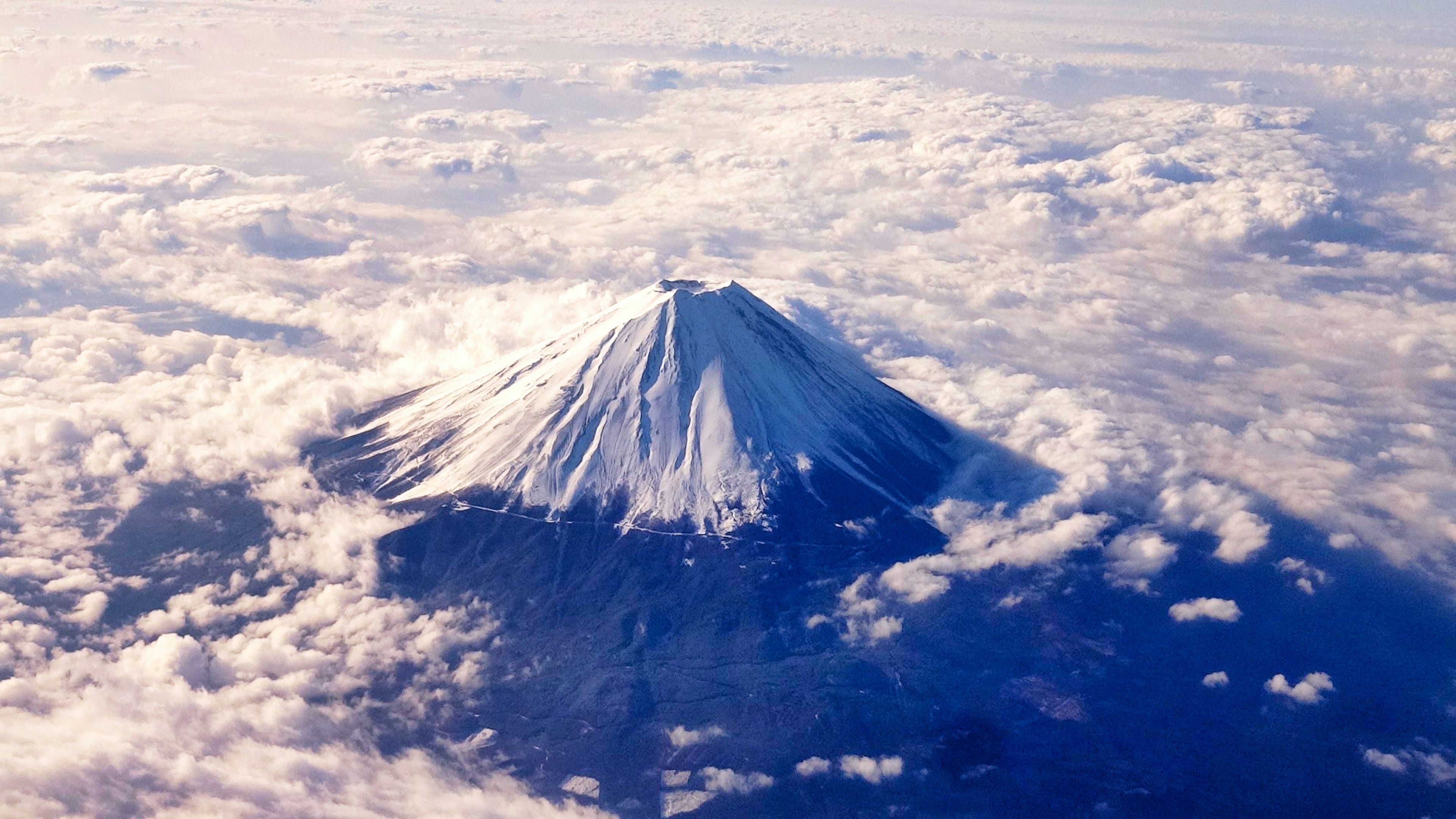 富士山の美しい空中写真 雲に囲まれた雪をかぶった頂上