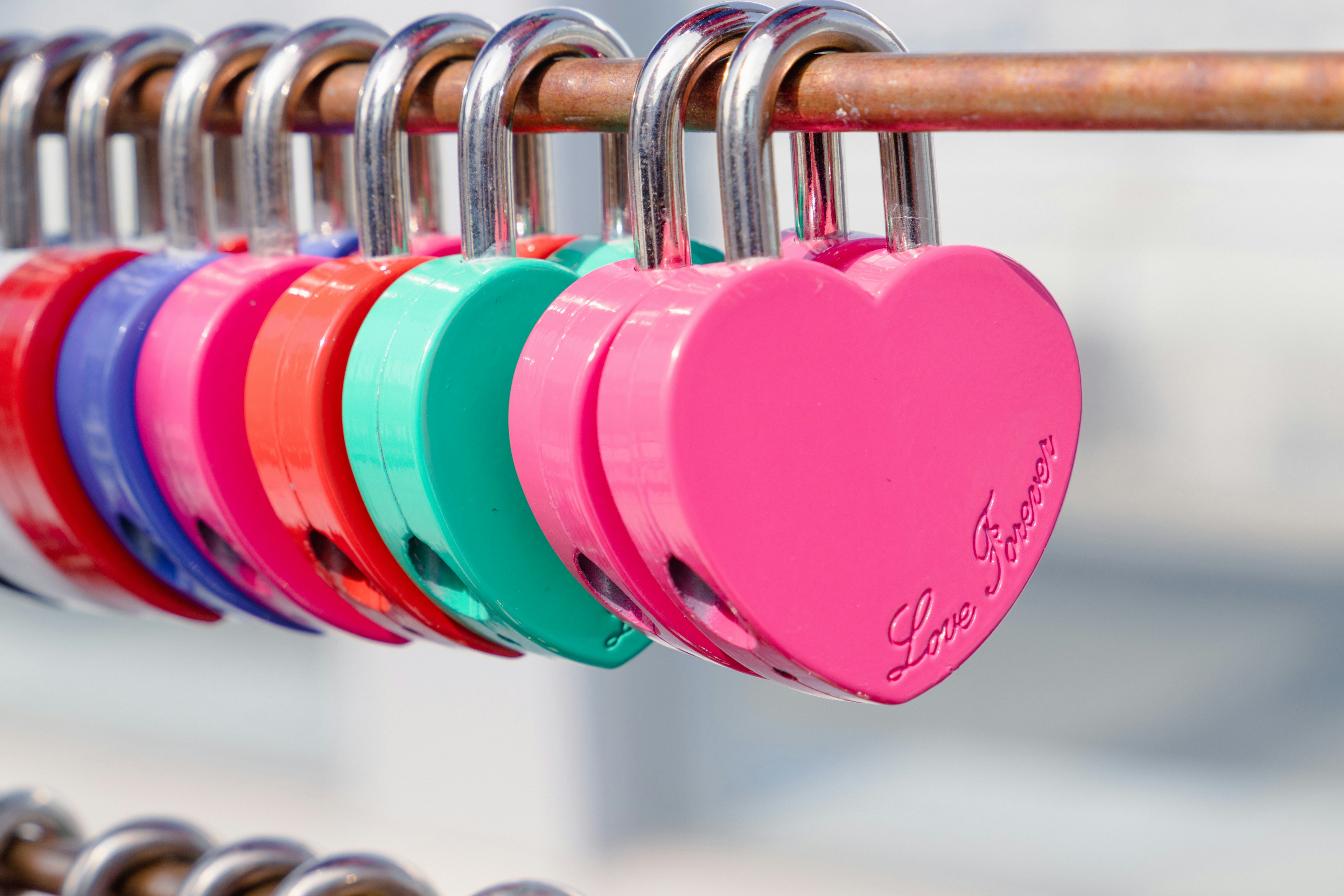 Colorful heart-shaped padlocks hanging on a railing