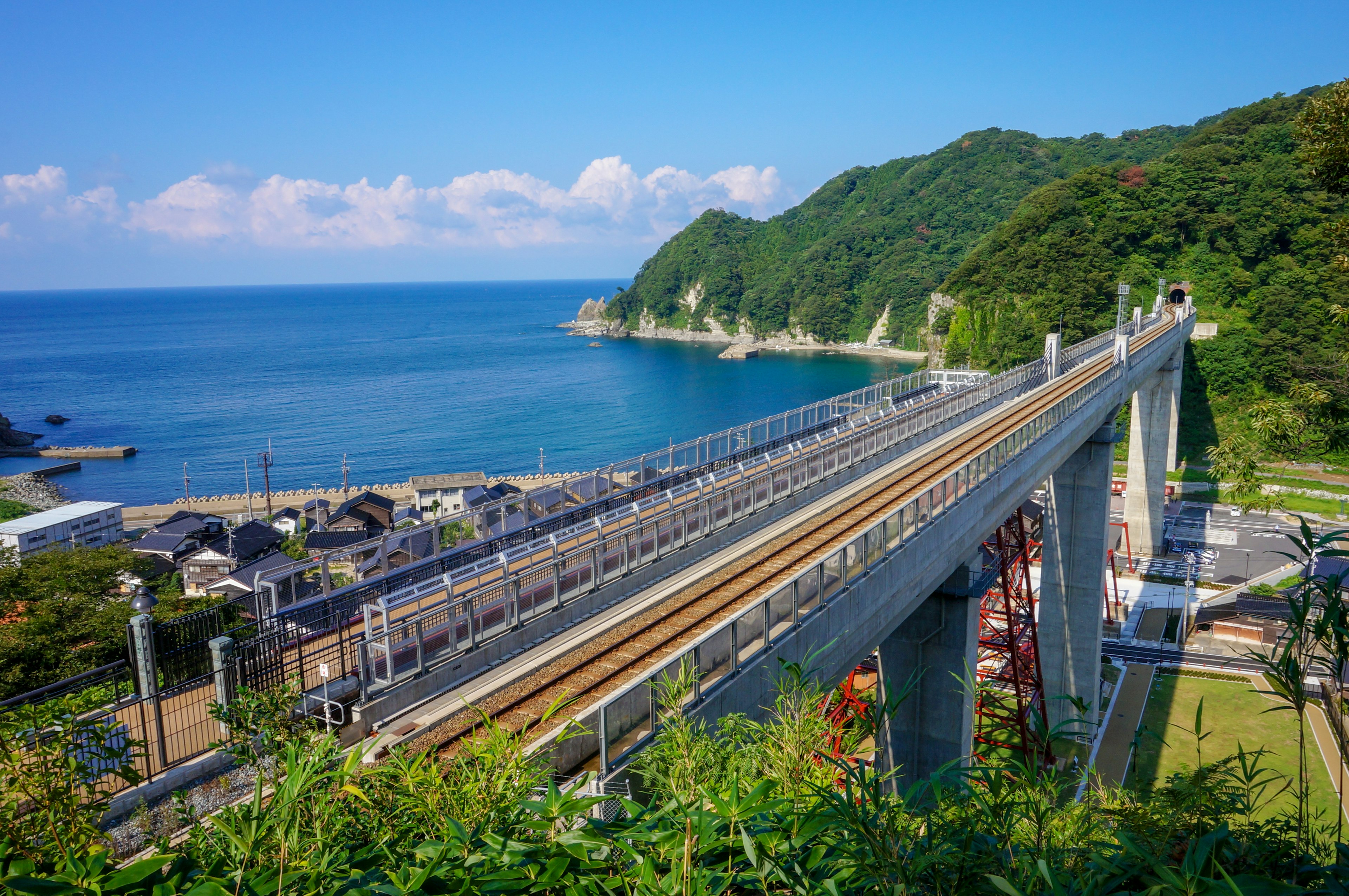 Ferrovia sopraelevata con vista sull'oceano e montagne