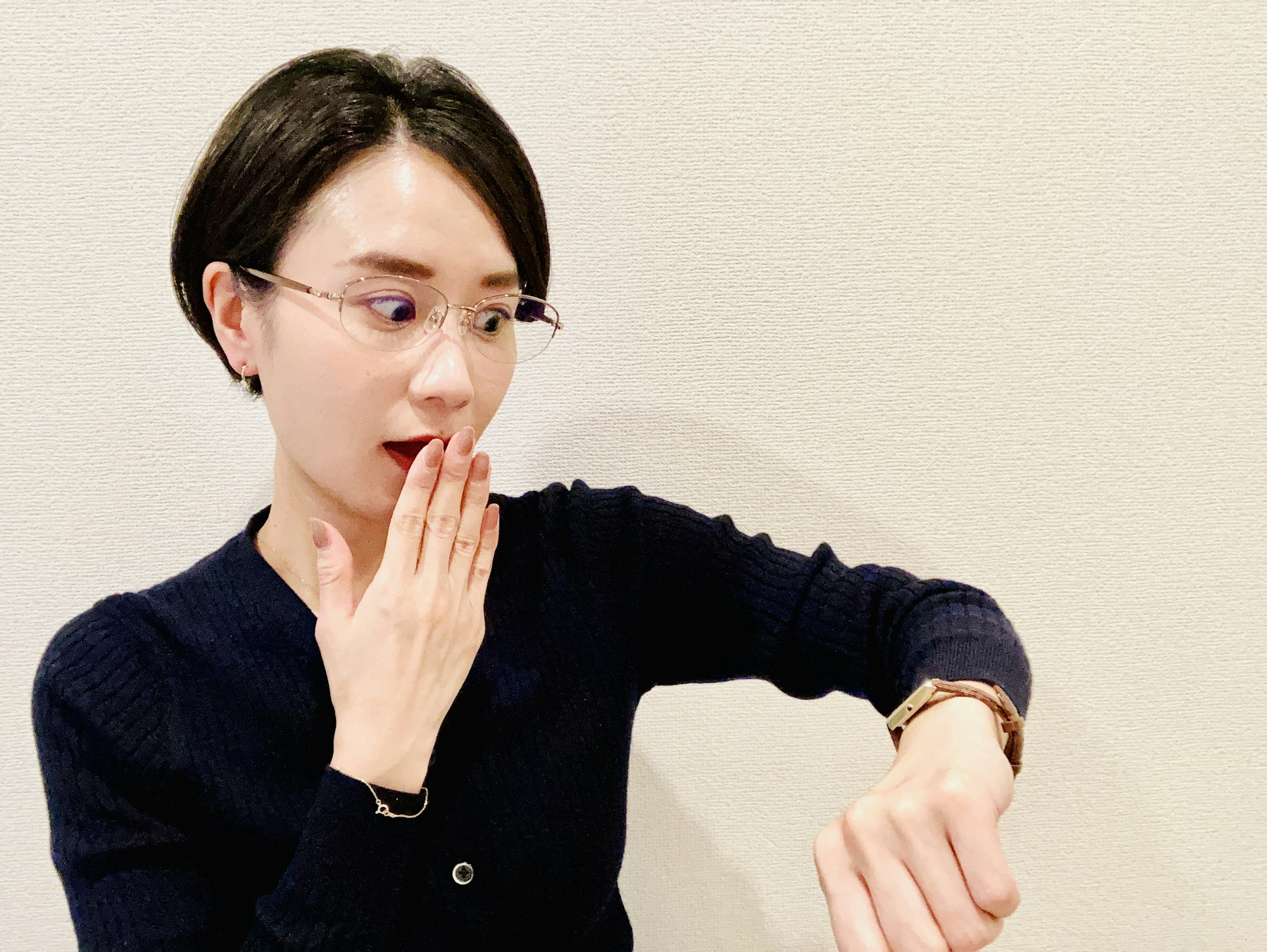 A surprised woman looking at her wristwatch