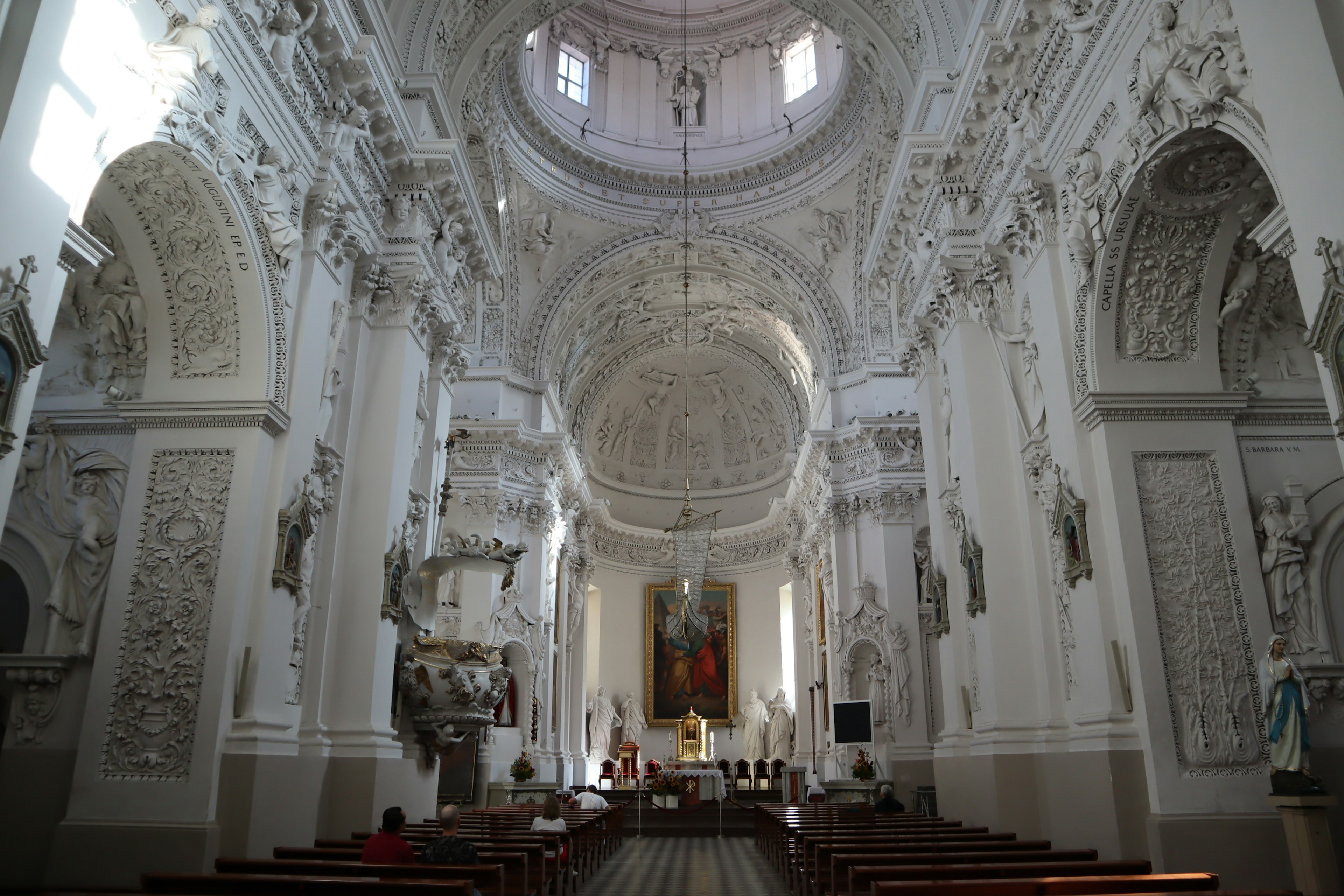 Innenraum einer schönen weißen Kirche mit aufwendigen Skulpturen und einer hohen Decke