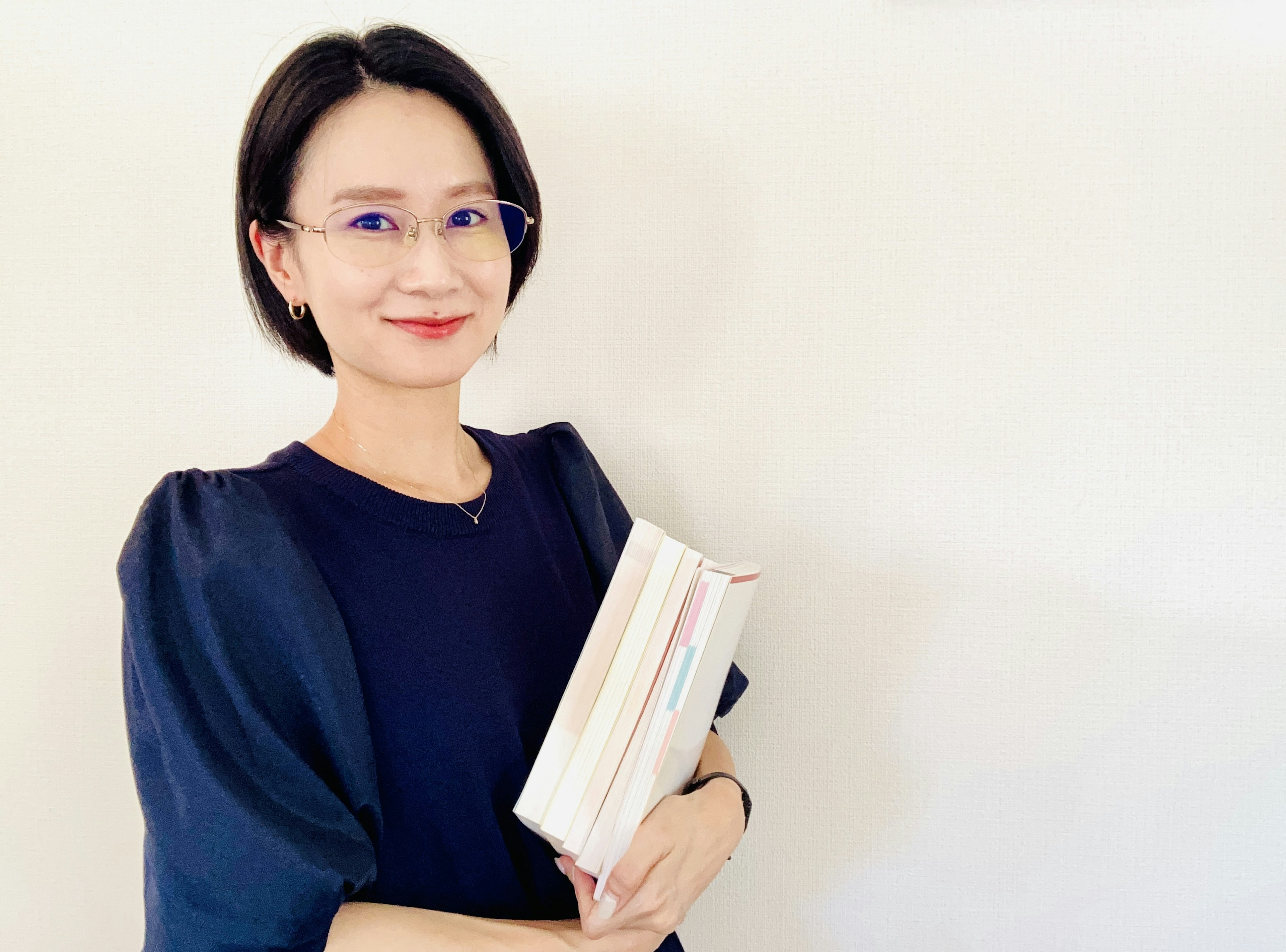 Portrait of a woman in a black top holding books