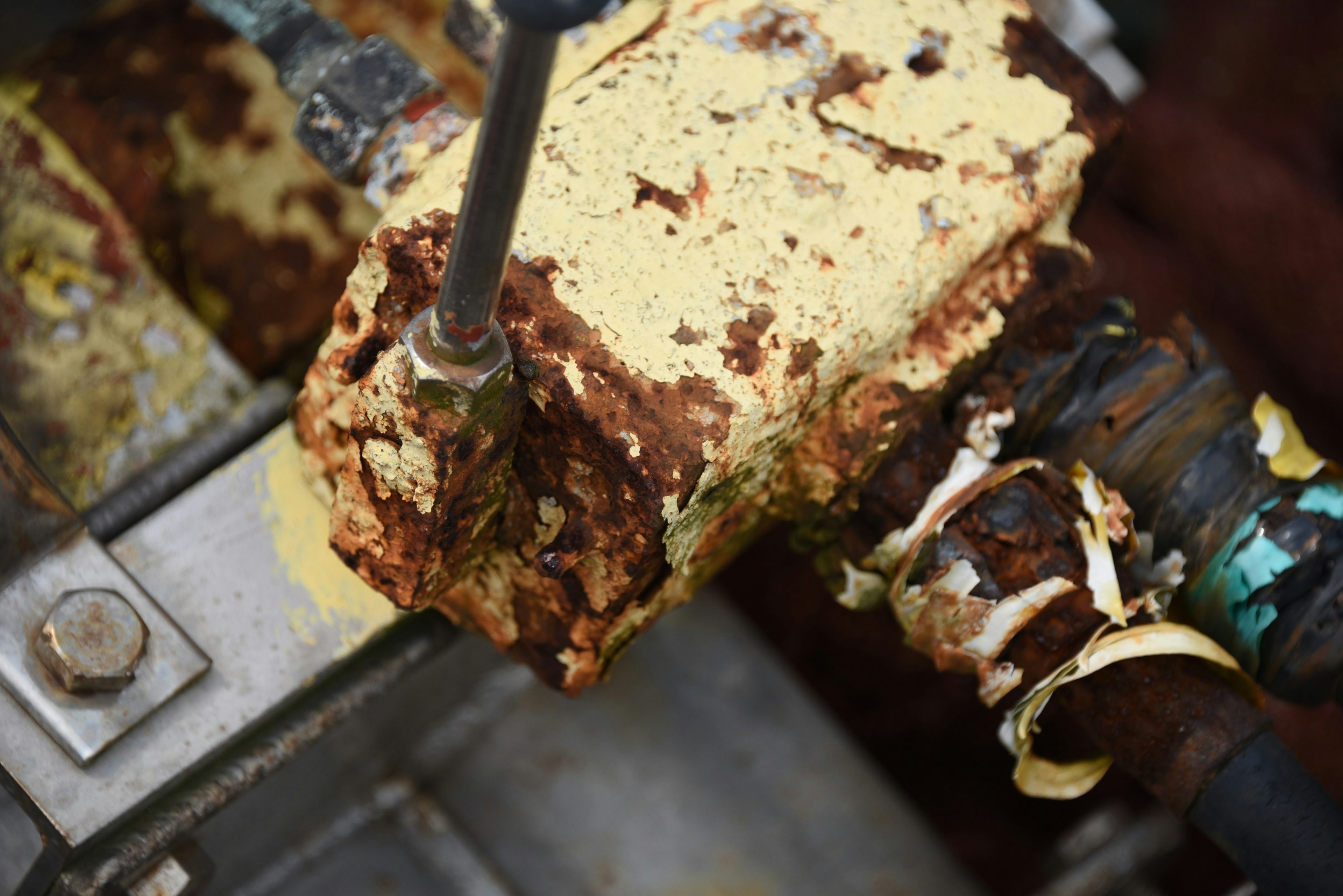 Rusty pipe with corroded yellow valve on industrial equipment