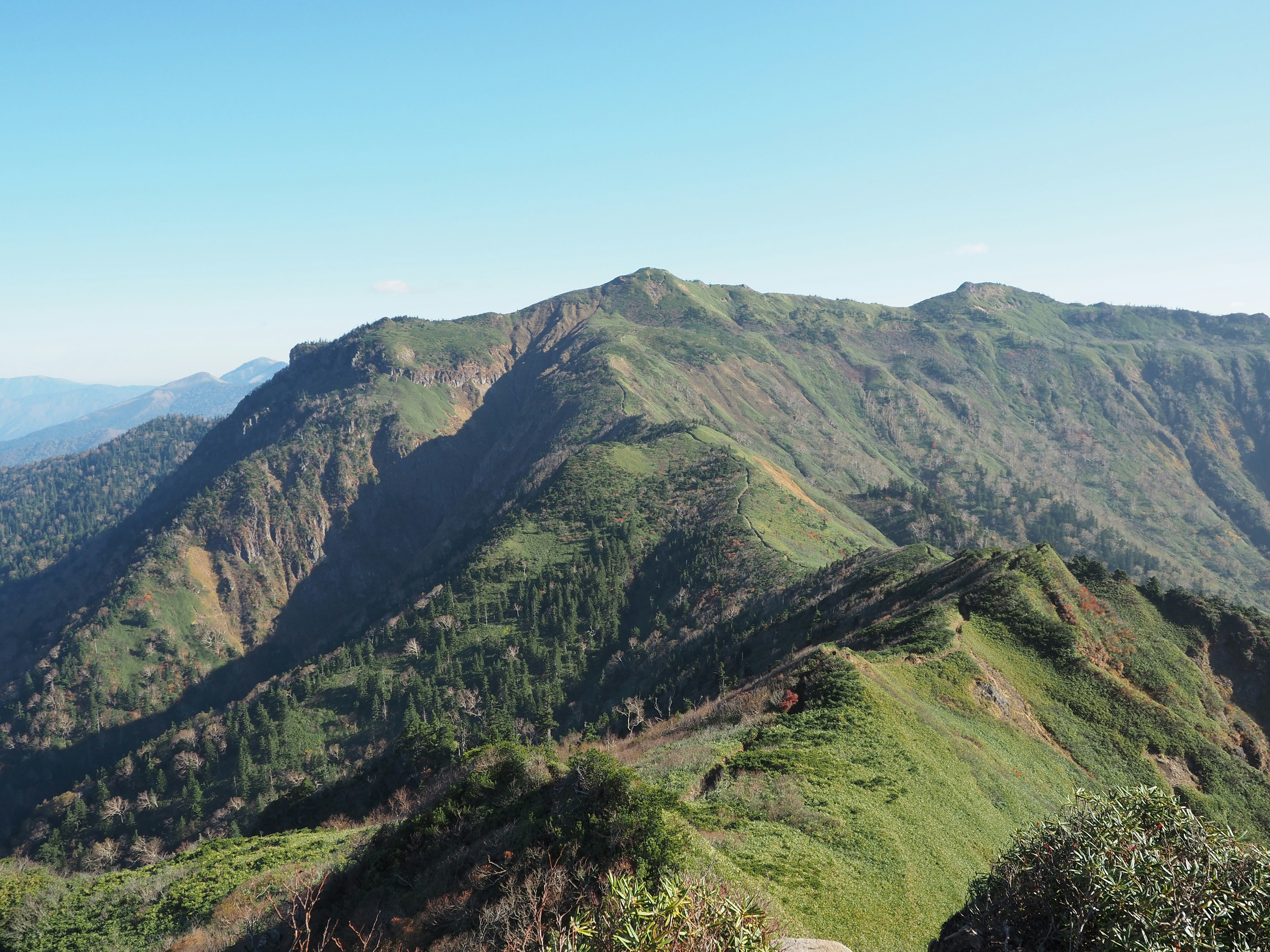 Montagnes verdoyantes sous un ciel bleu clair