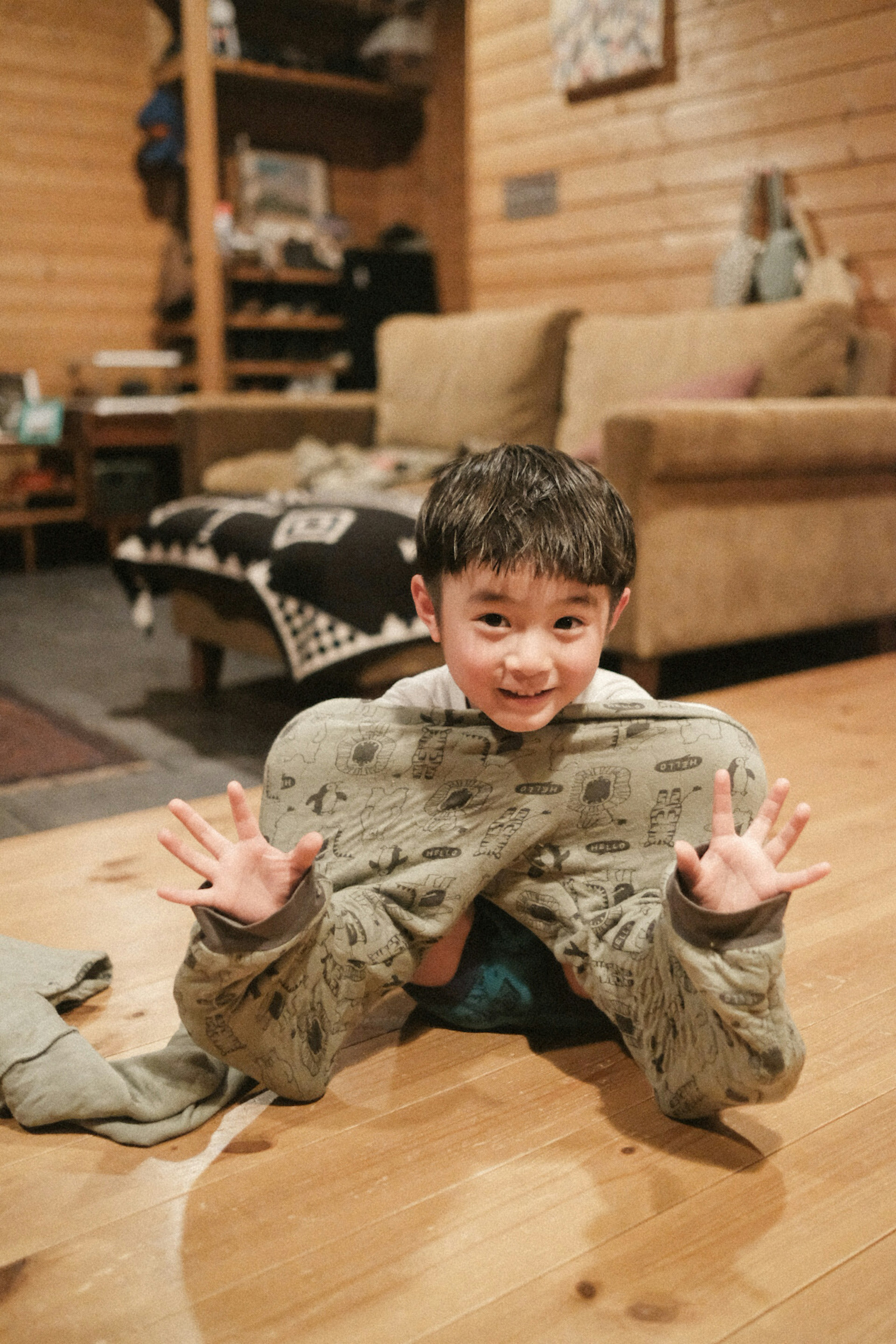 A child playing with a blanket in a cozy indoor setting