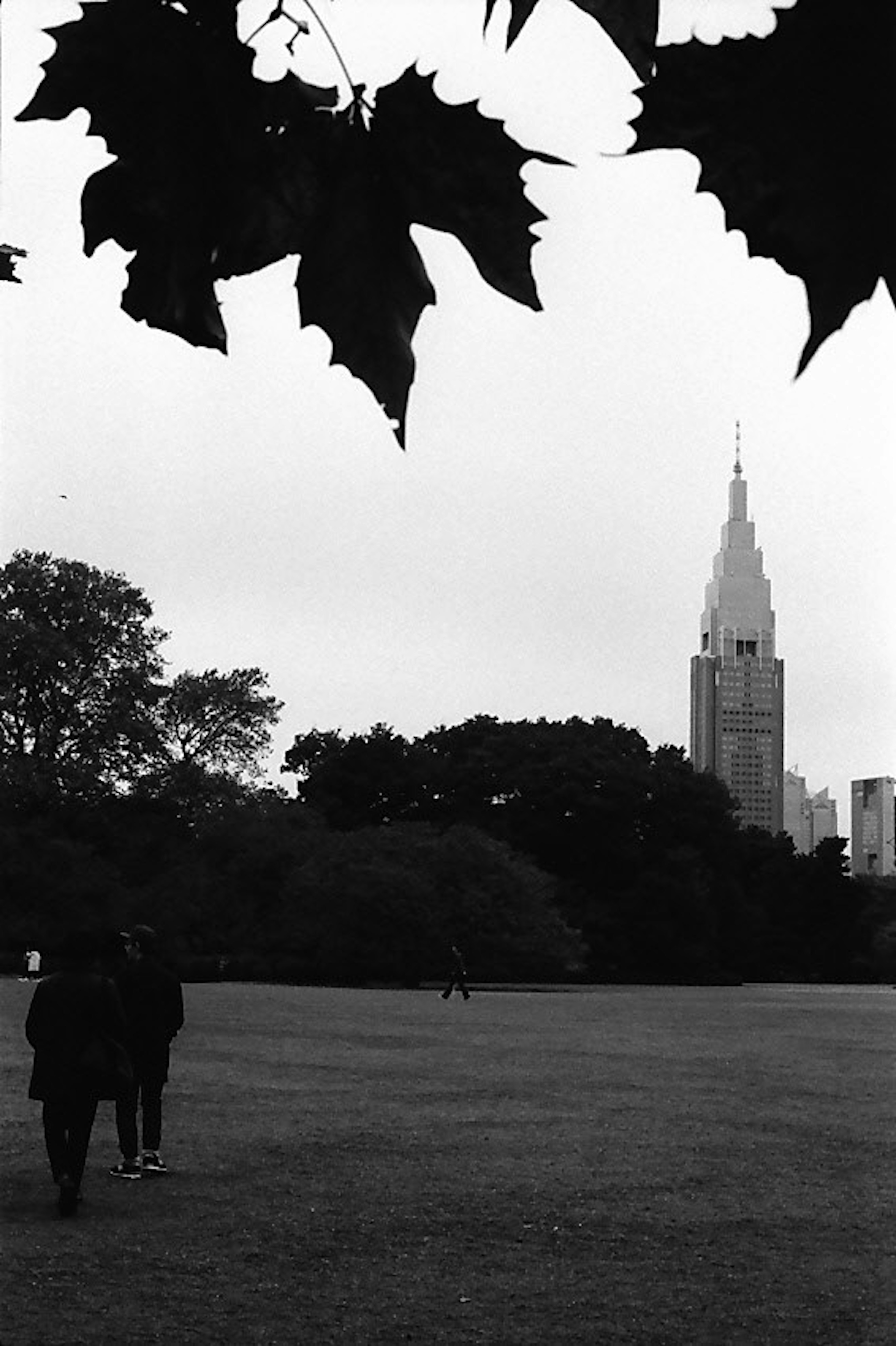 Pemandangan hitam putih dengan Empire State Building dan orang-orang yang berjalan