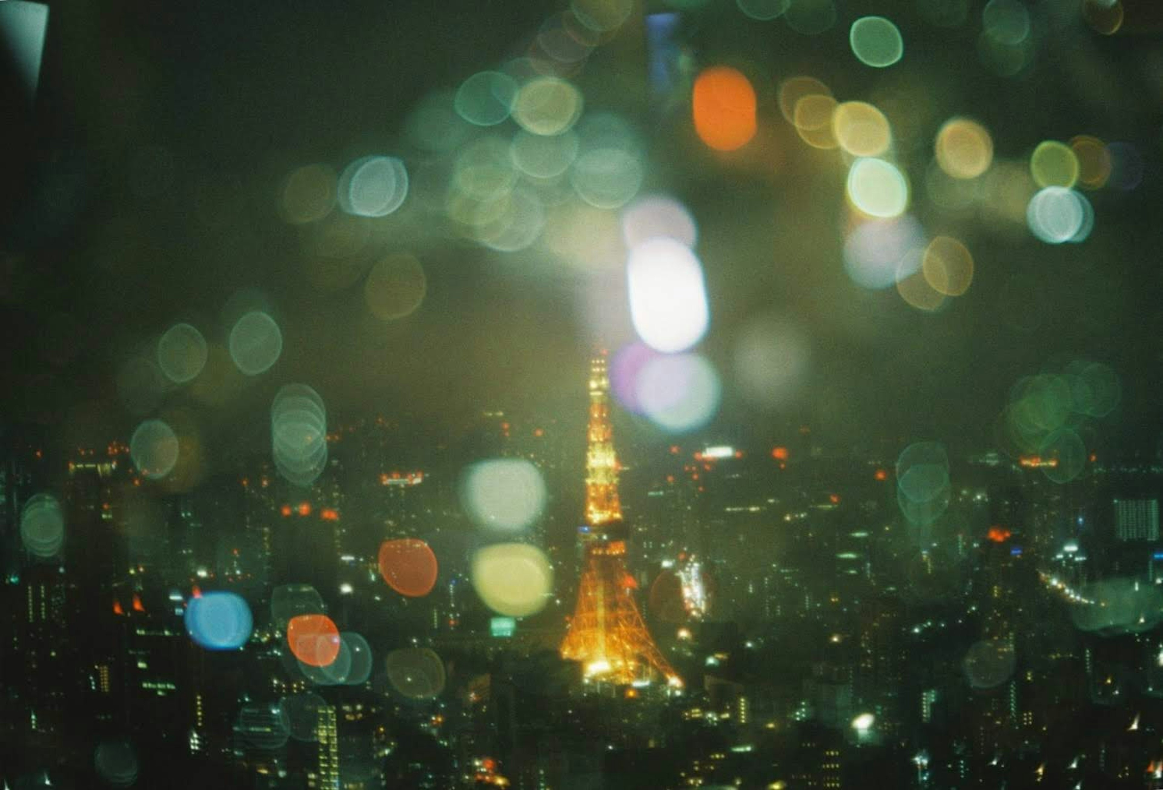 Vista notturna sfocata della Torre di Tokyo con luci colorate sullo sfondo