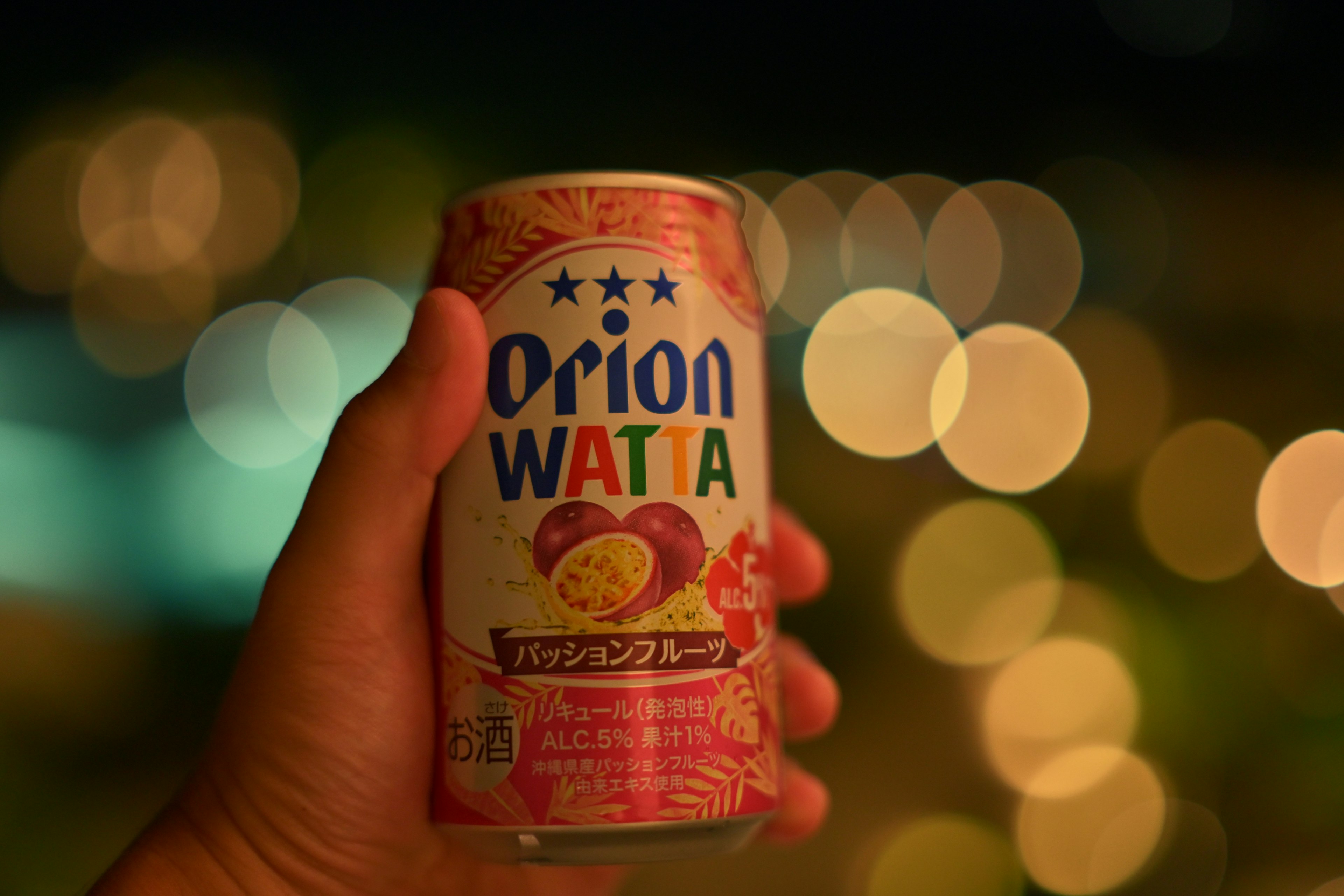 手握著一罐Orion WATTA，背景模糊美麗