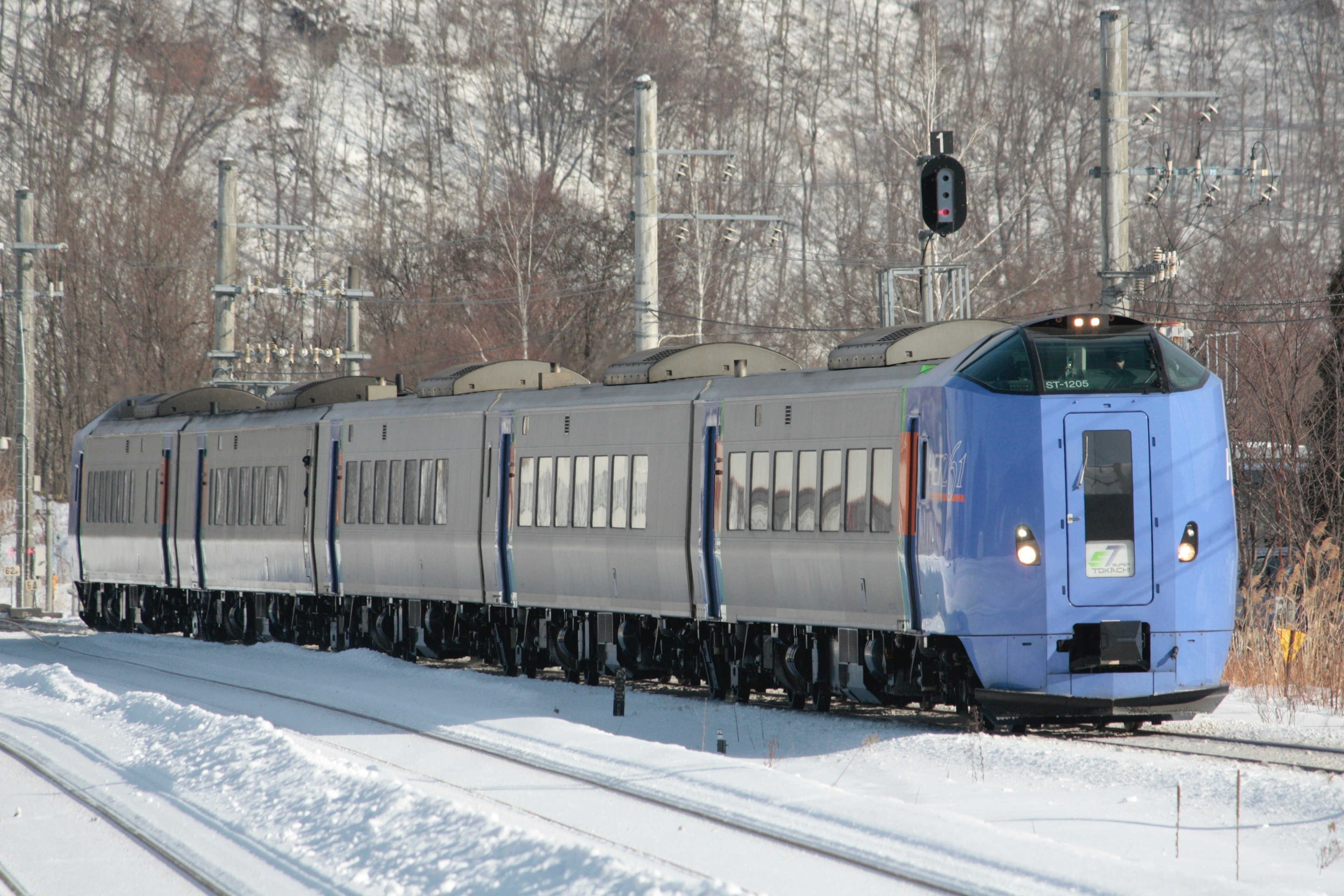 Kereta ekspres biru yang melaju di tengah salju