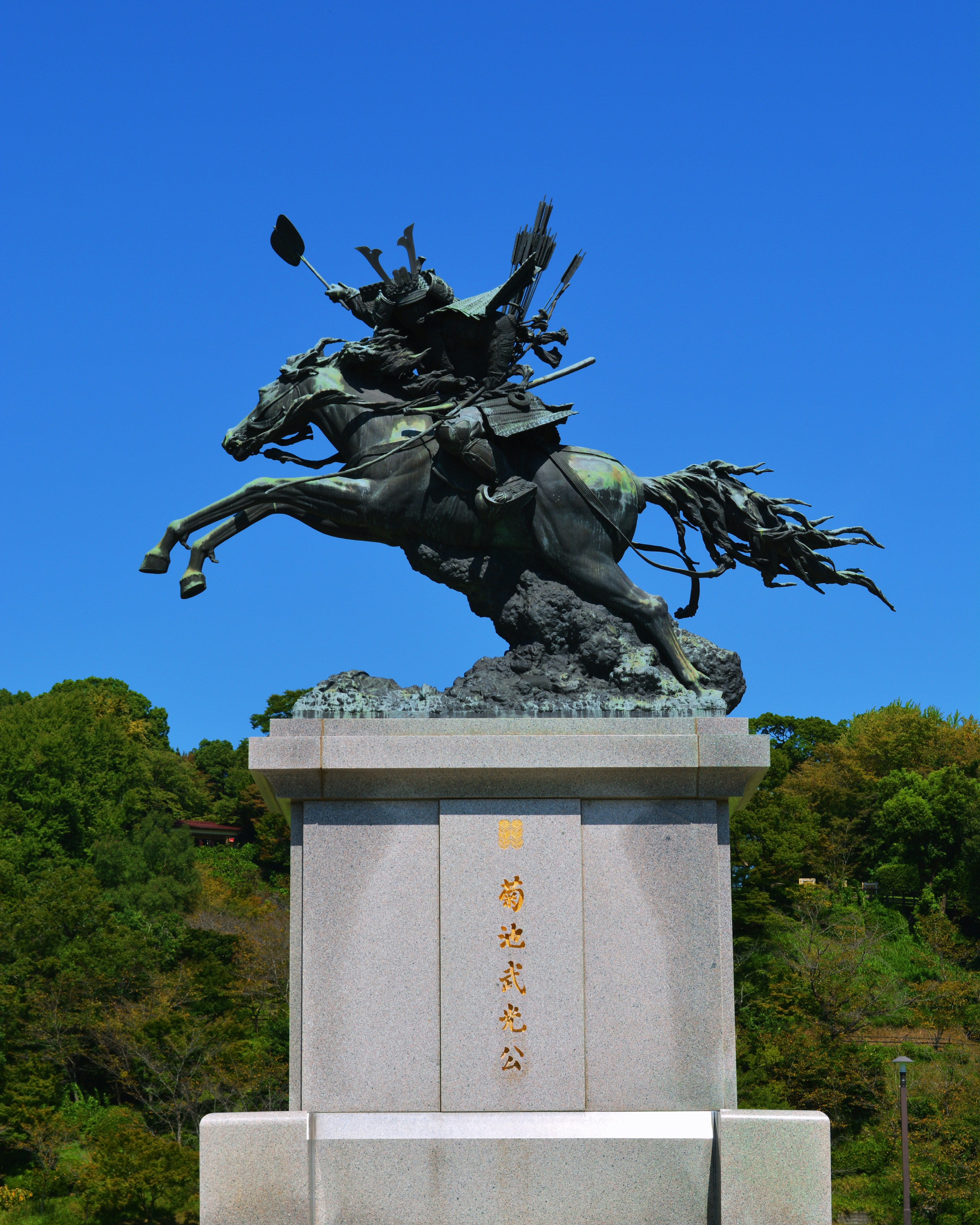 Estatua de bronce de un guerrero a caballo bajo un cielo azul