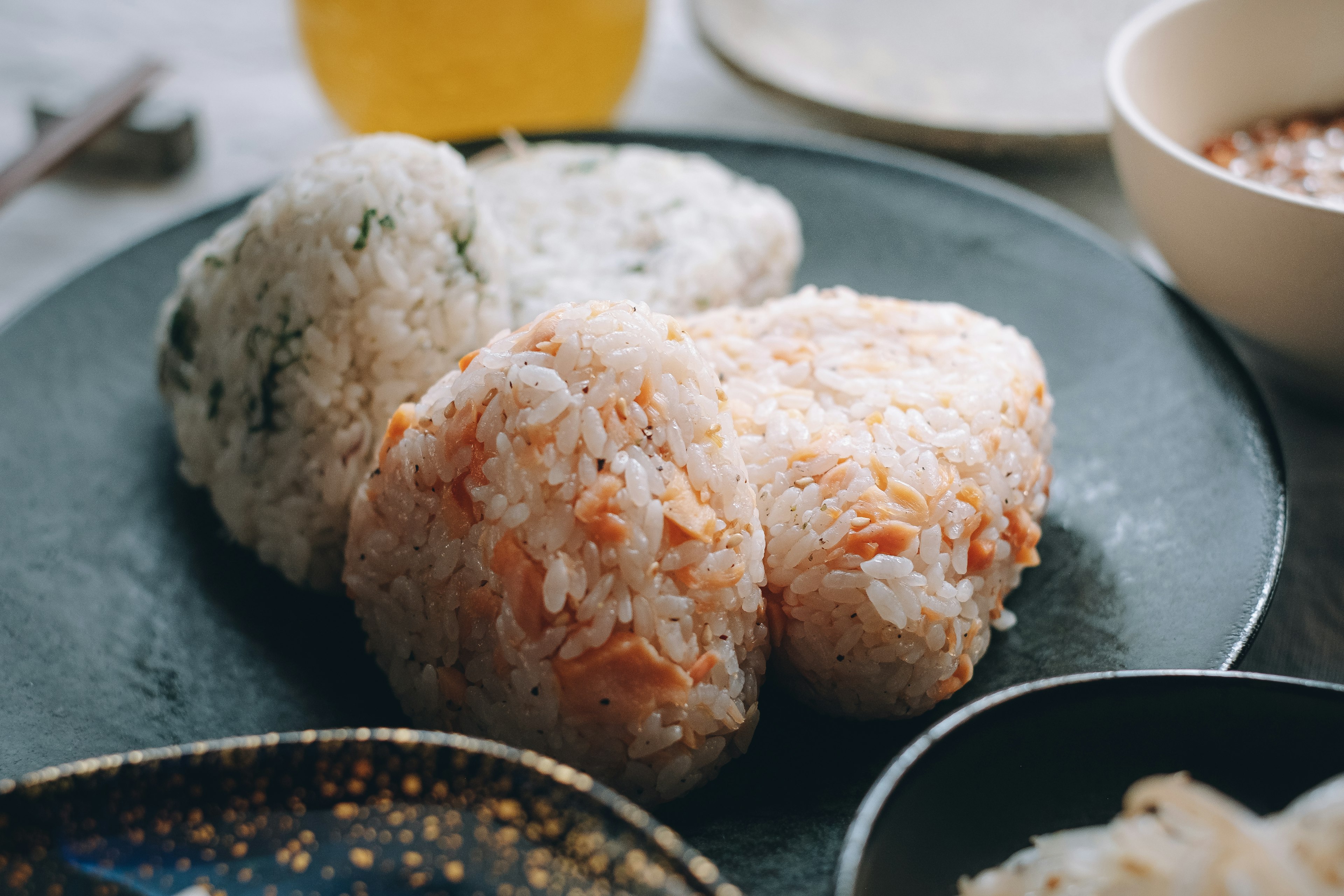 A plate of onigiri rice balls with a drink