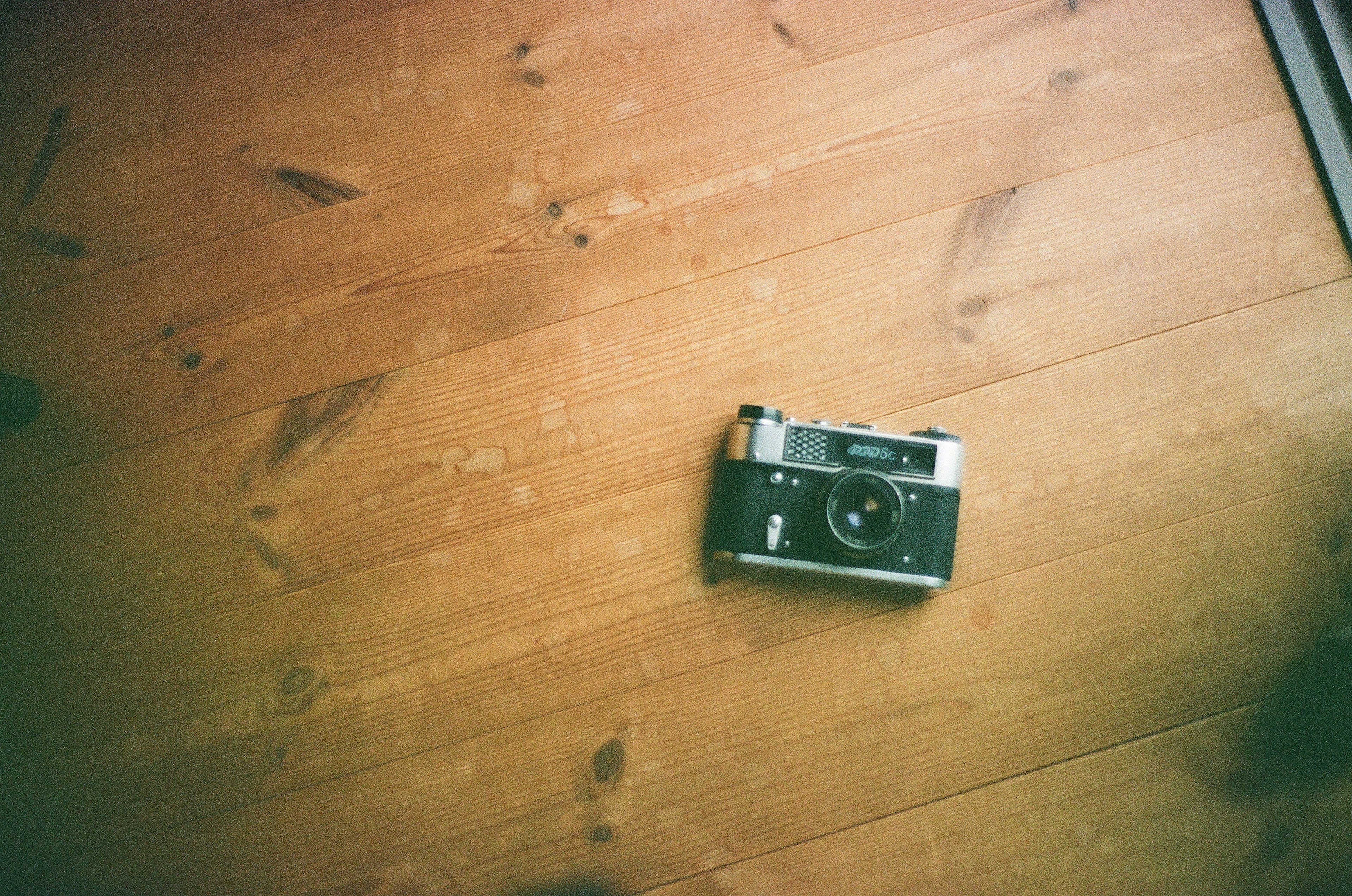 Macchina fotografica a pellicola su un pavimento in legno