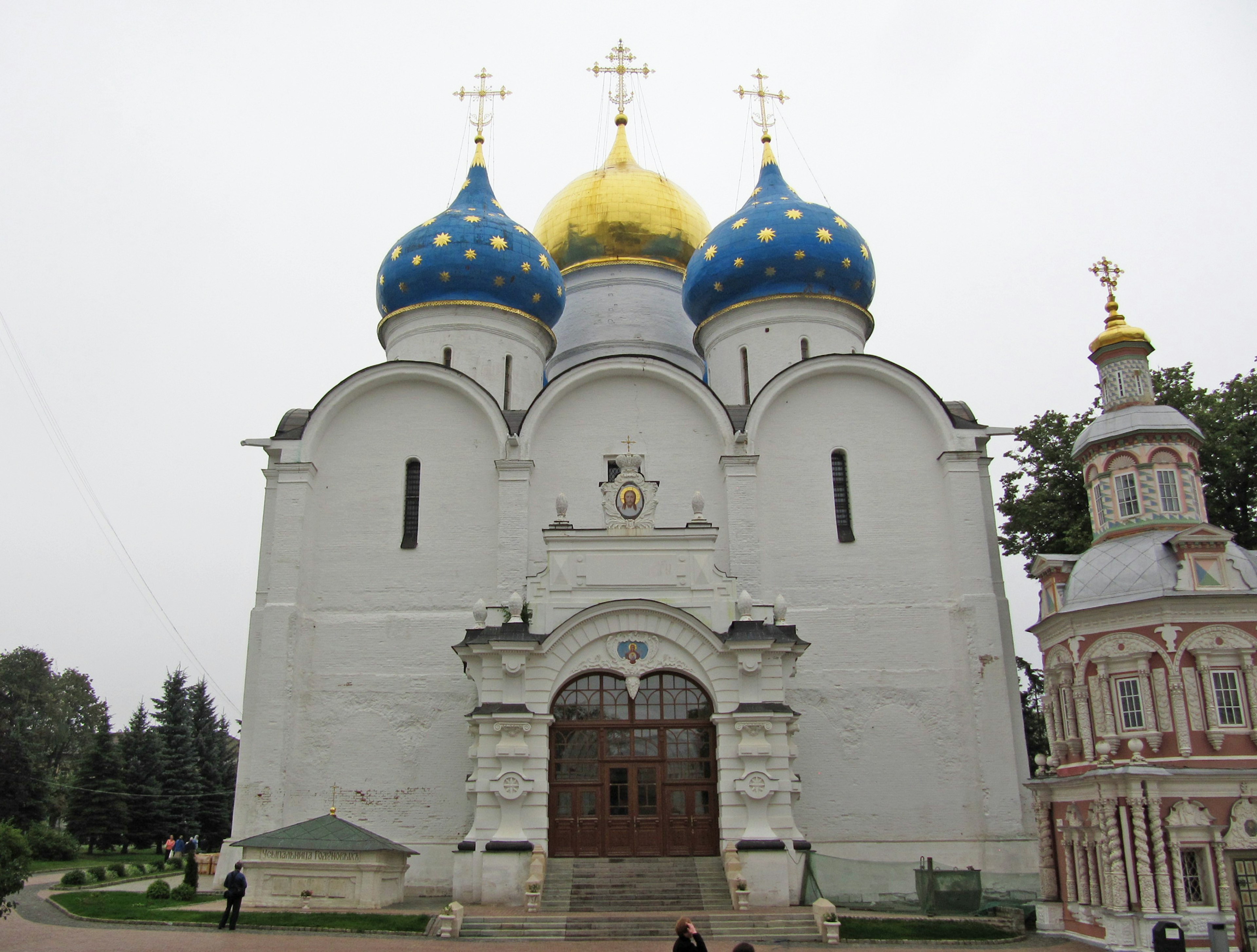 Extérieur d'une église blanche avec des dômes bleus et dorés