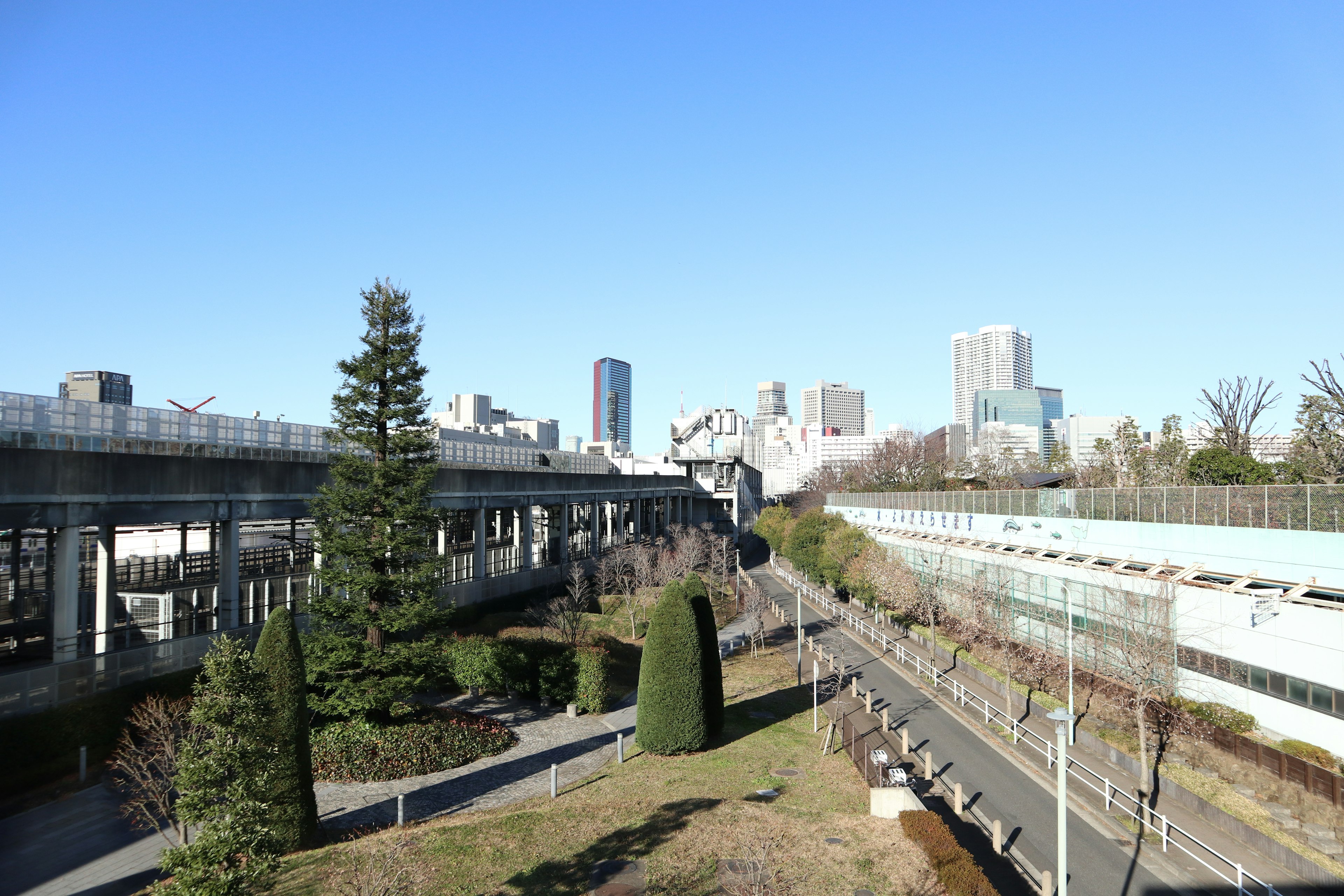 Paisaje urbano bajo un cielo azul con autopistas y vegetación