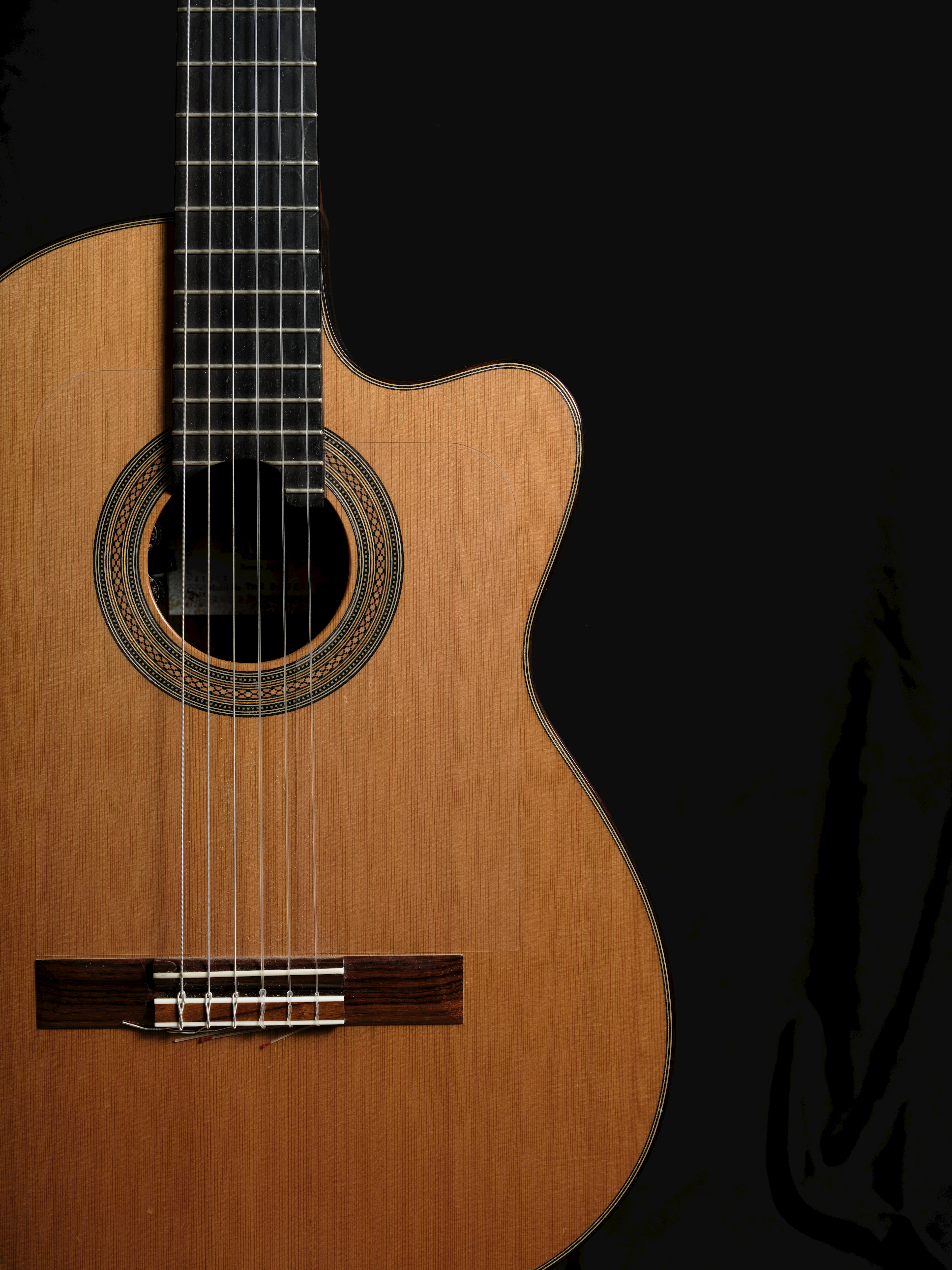 Vista laterale di una bella chitarra acustica su sfondo nero