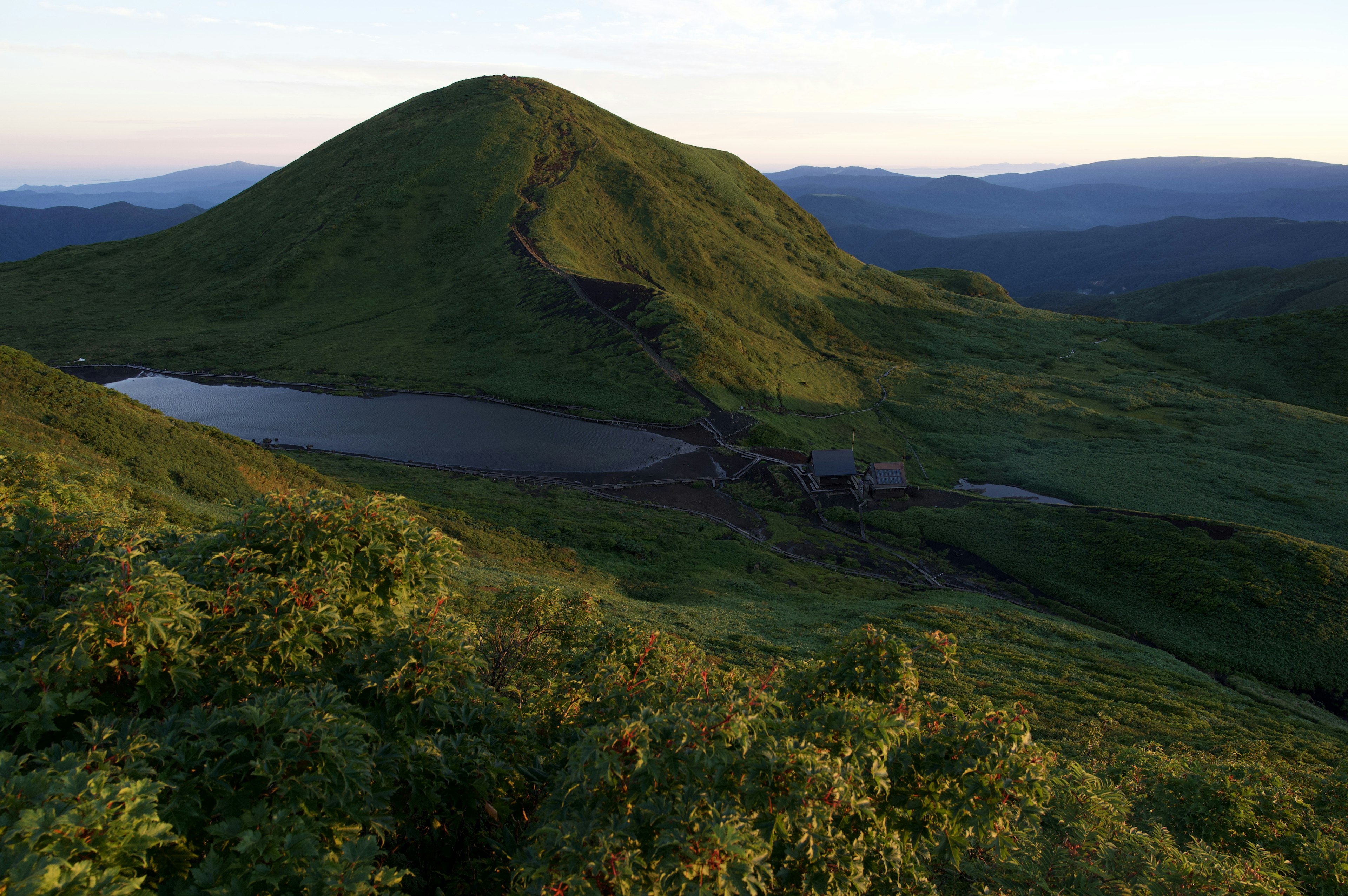 Üppige grüne Berglandschaft mit einem ruhigen See