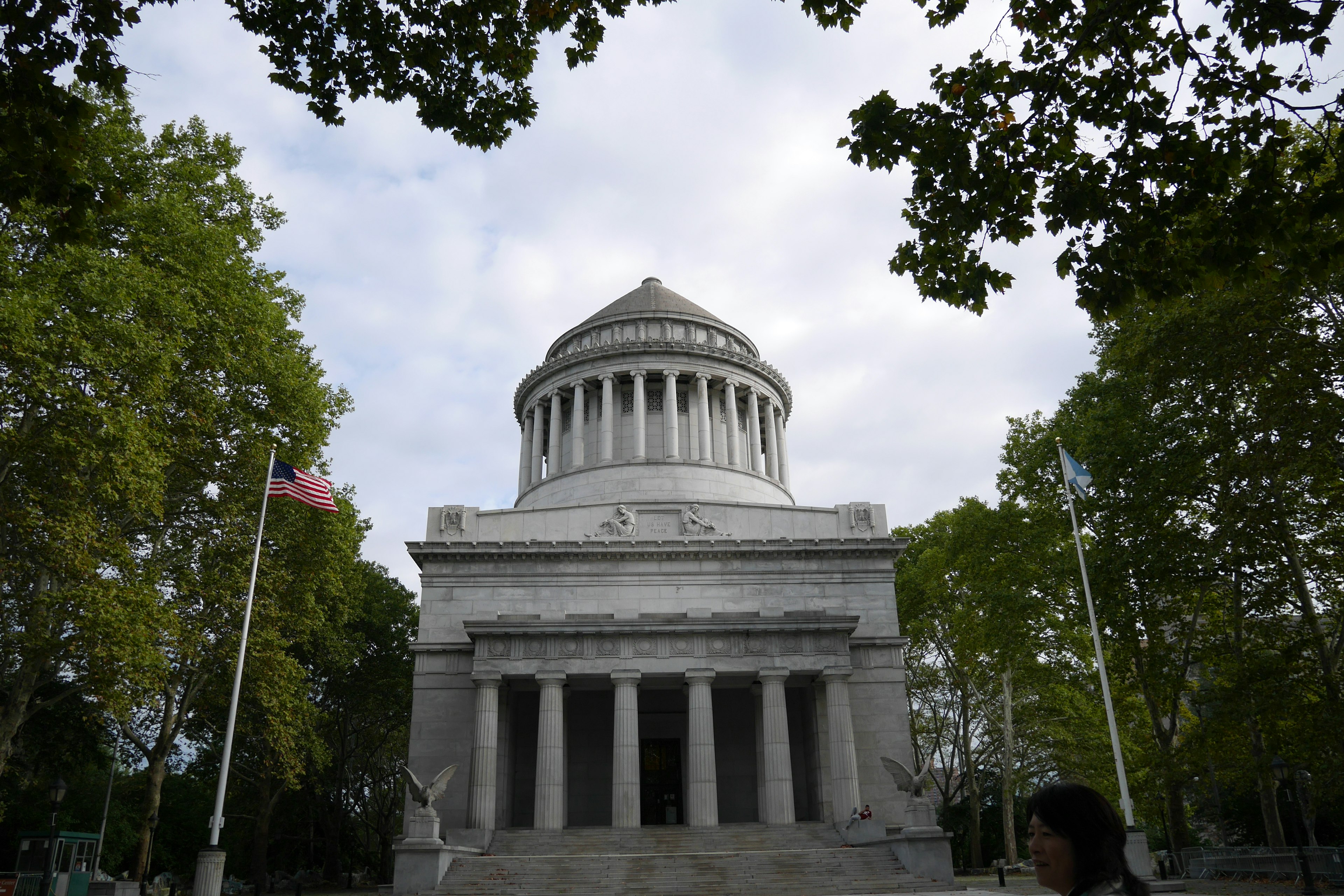 Vista frontal de un monumento con columnas robustas y un techo en forma de cúpula con una bandera estadounidense exhibida