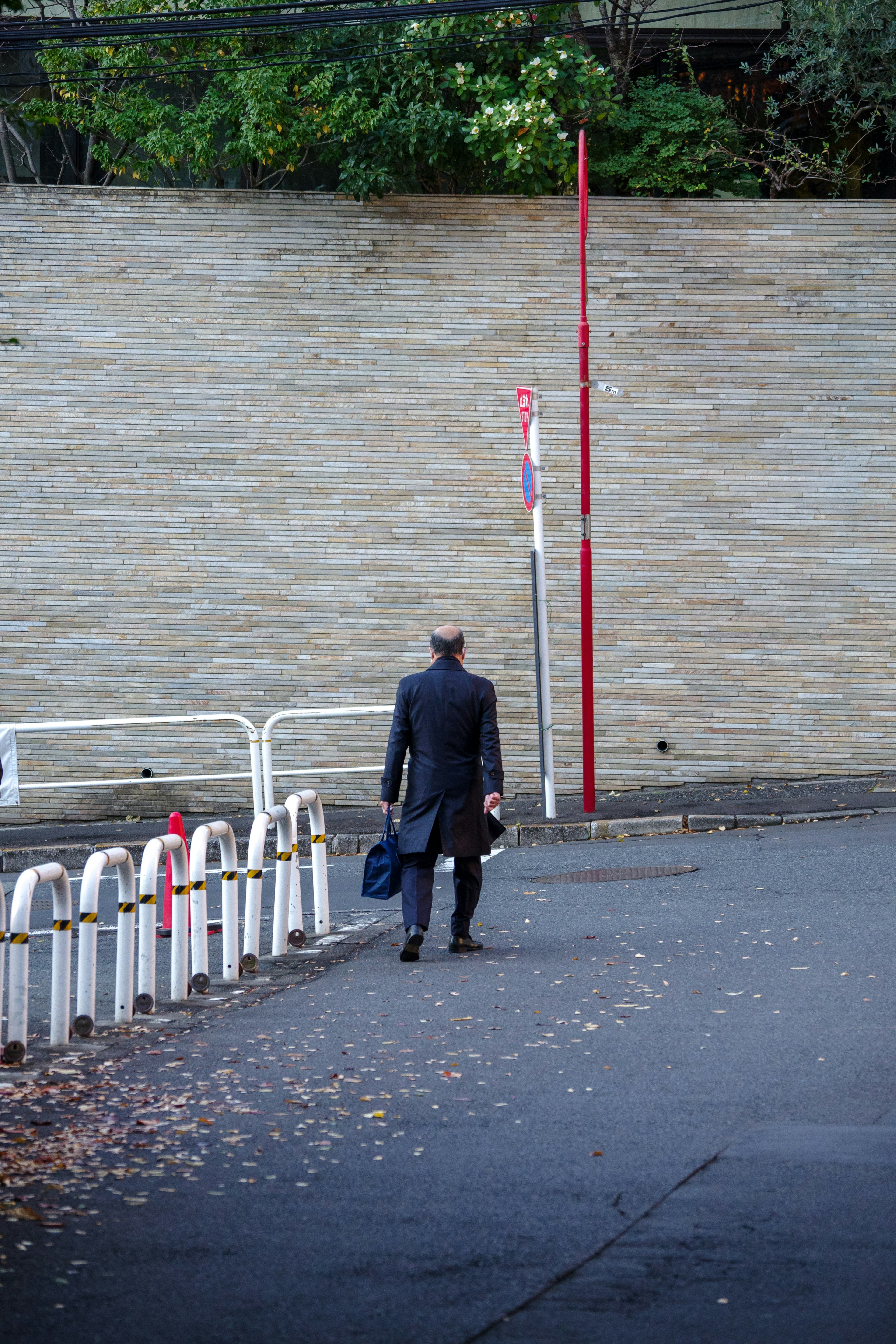 A suited man walking away with a briefcase