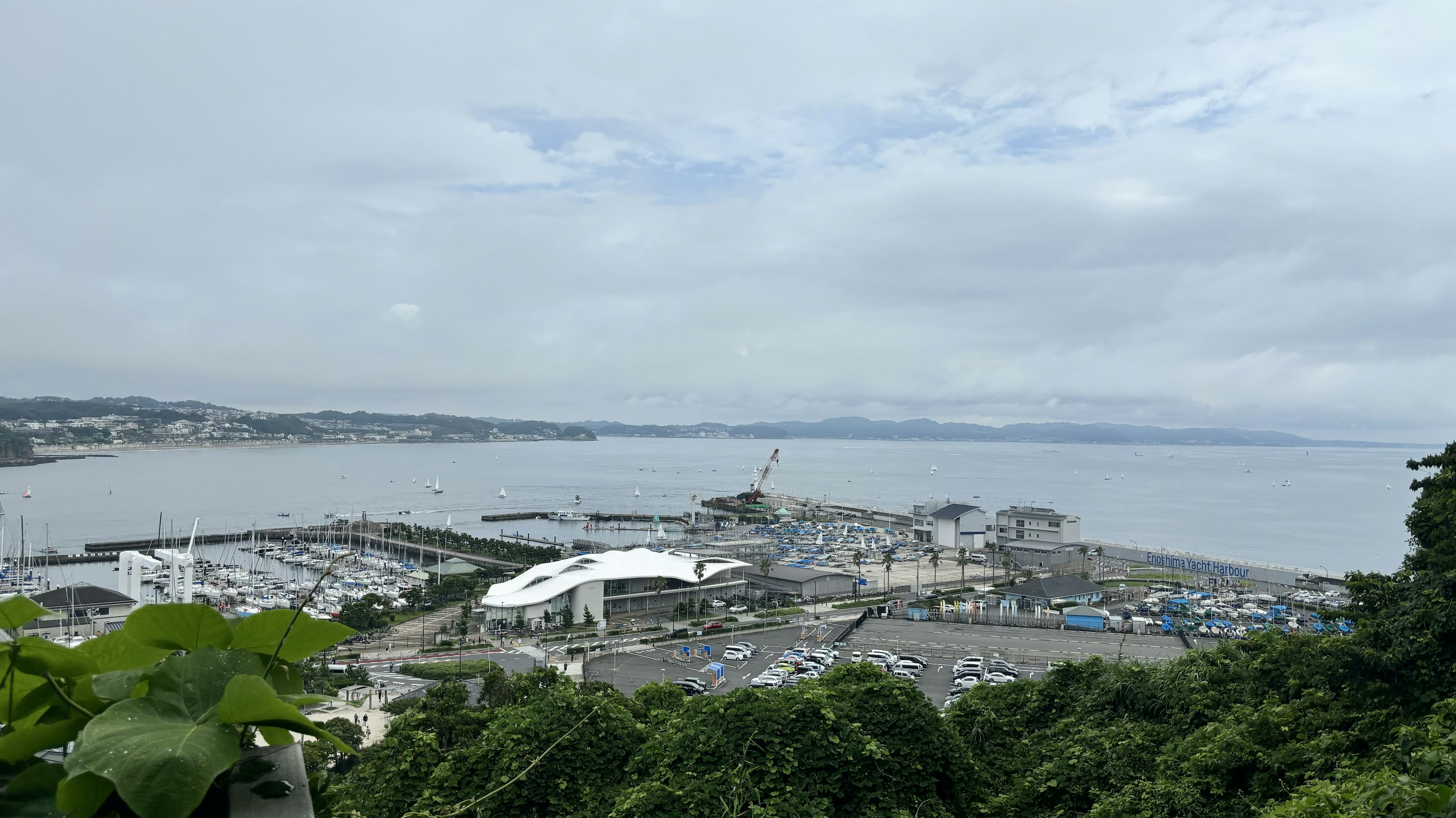 Vista del puerto costero con cielo nublado y follaje verde