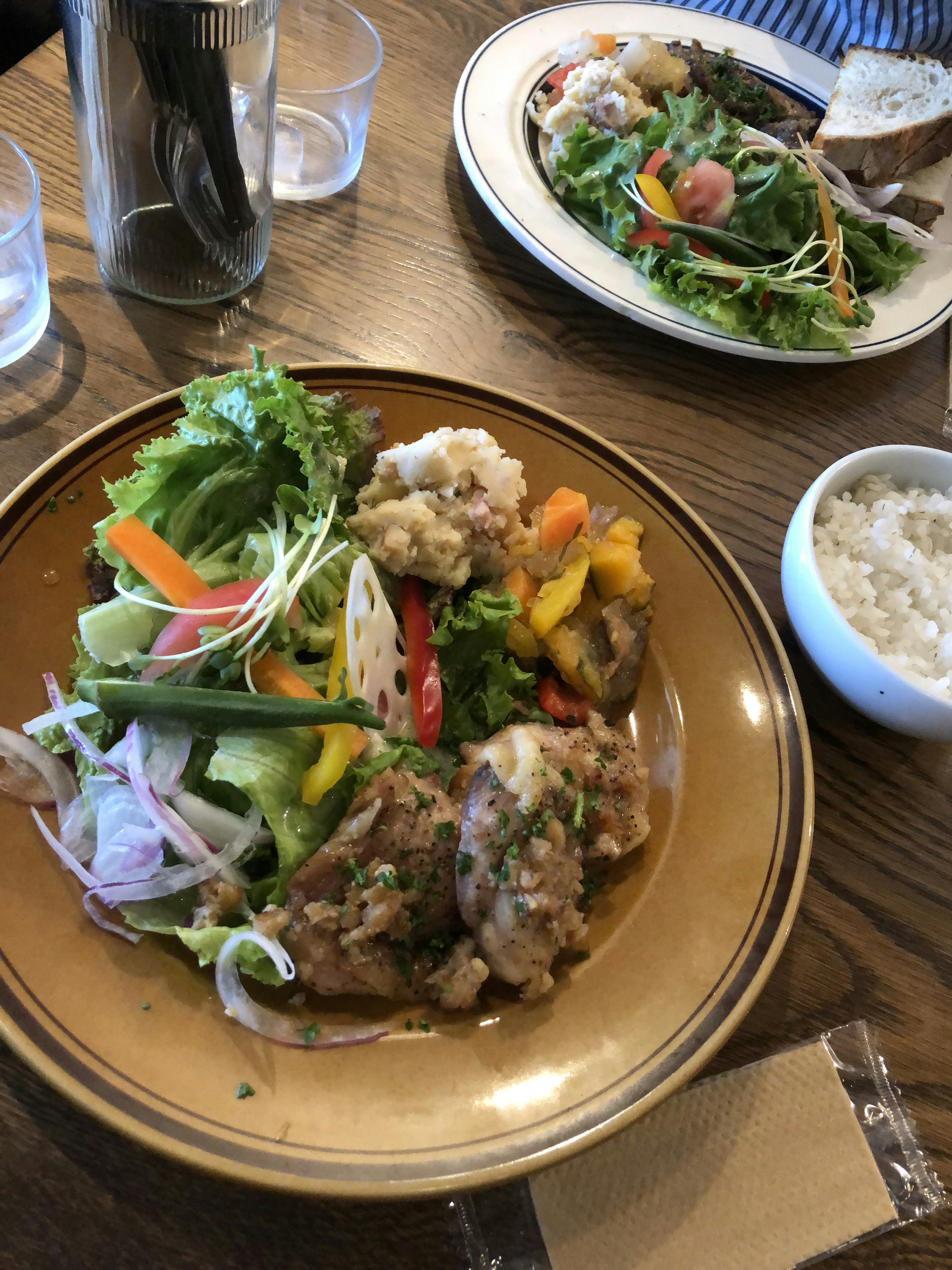 Une assiette de légumes colorés et de poulet avec une salade et du riz