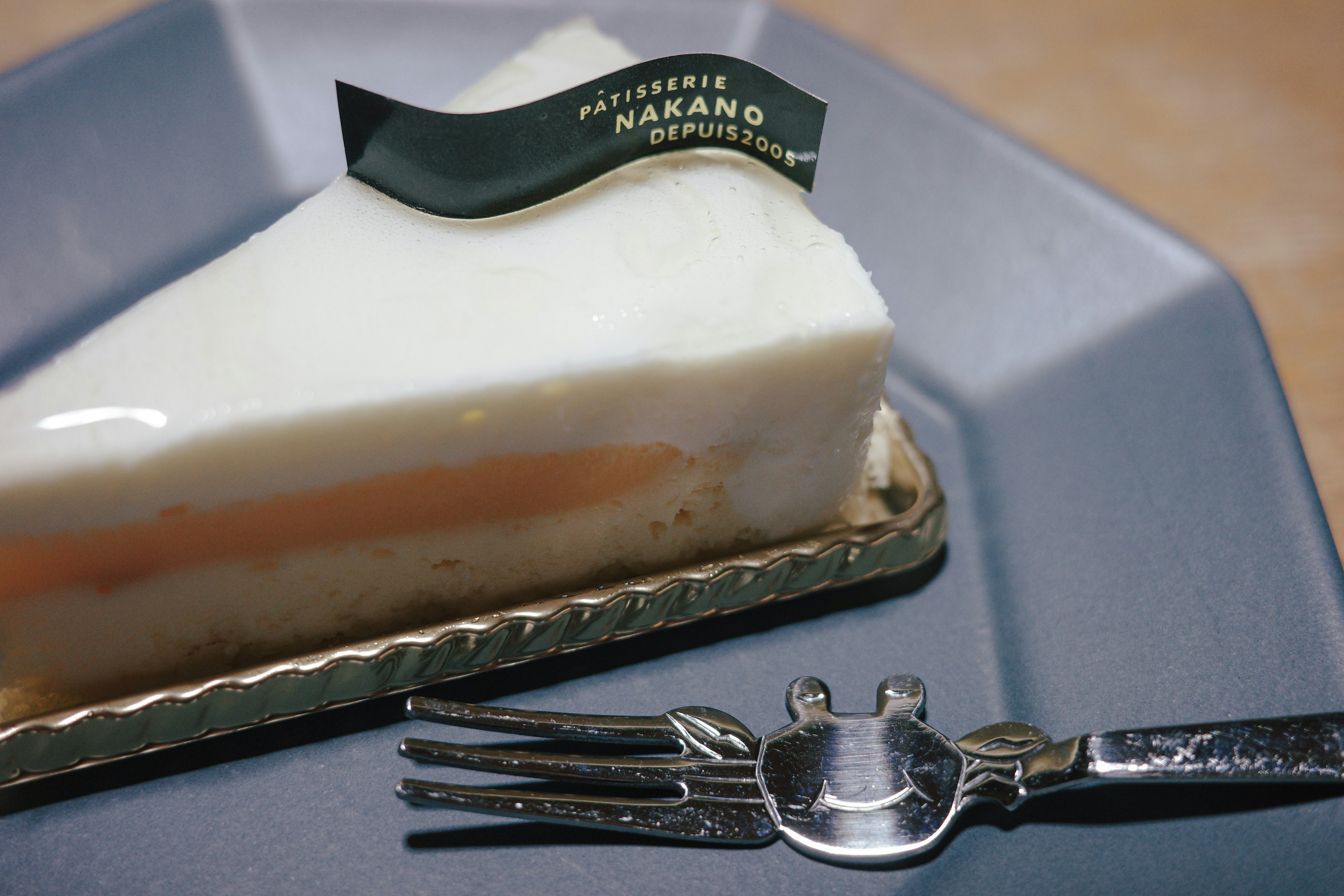 Tranche de gâteau blanc avec une couche orange et un dessus en logo vert