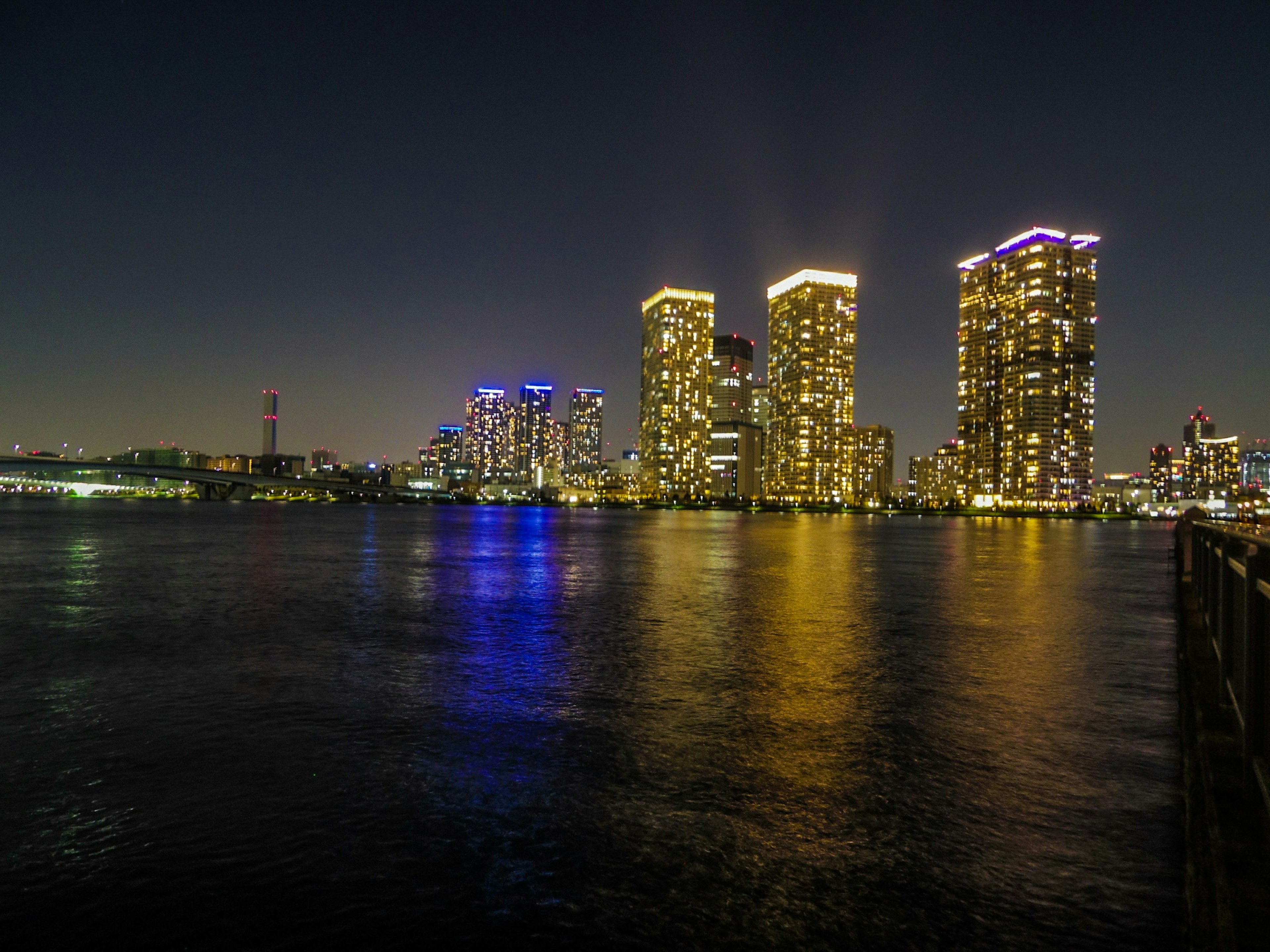 Night view of illuminated skyscrapers reflecting on water