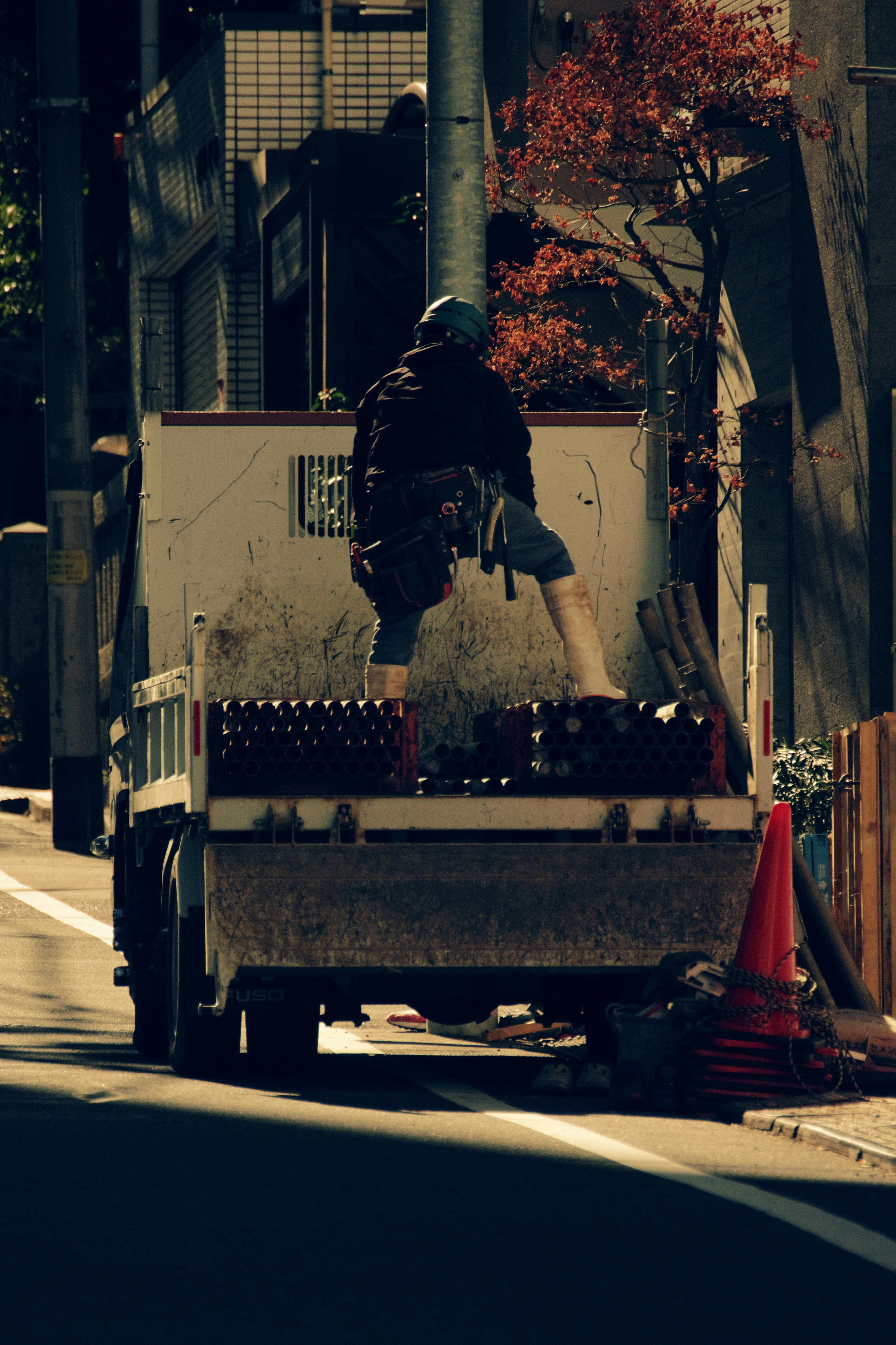 Ouvrier debout sur un camion sur un site de construction avec des environs urbains