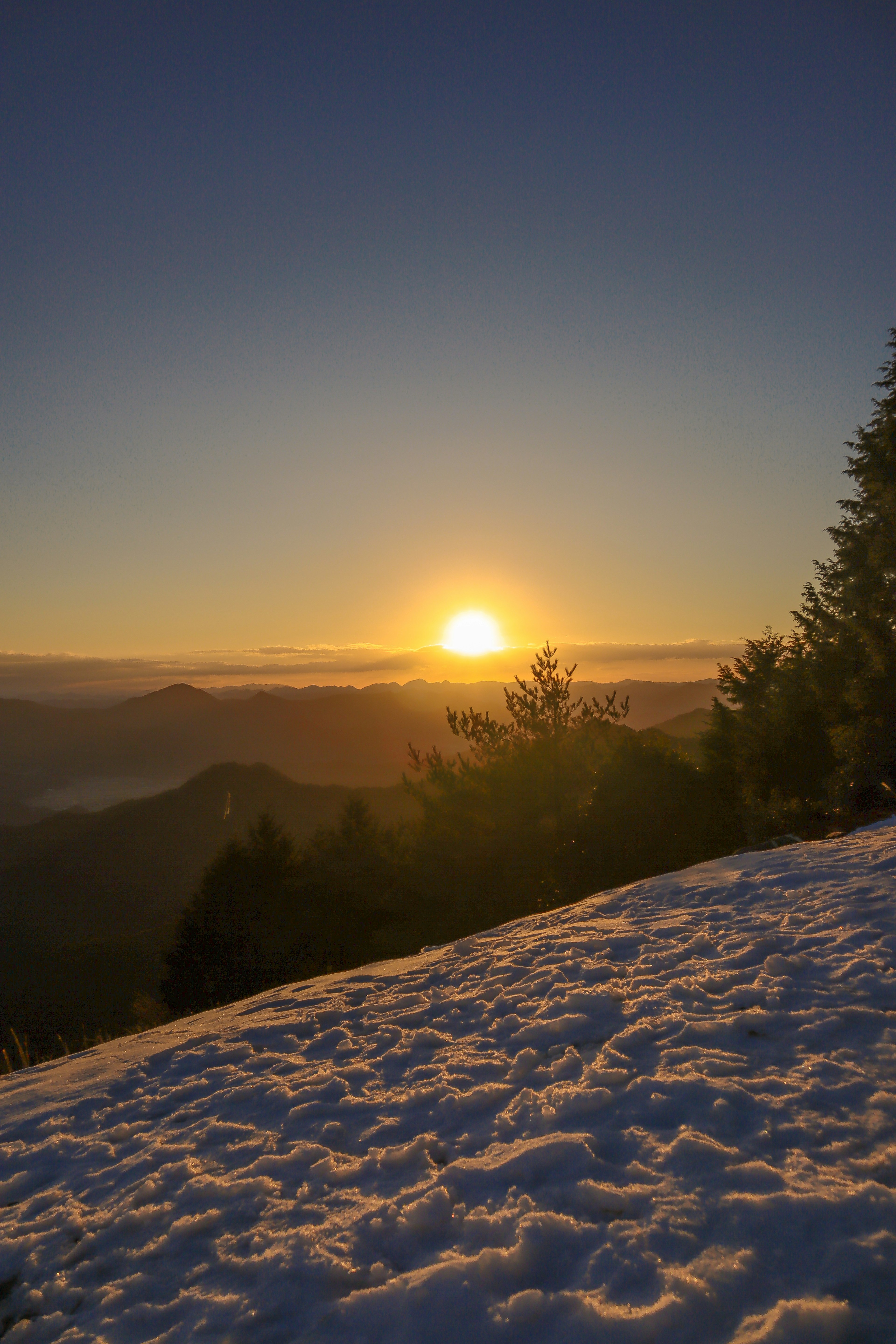 Belle vue du soleil se levant sur une colline enneigée