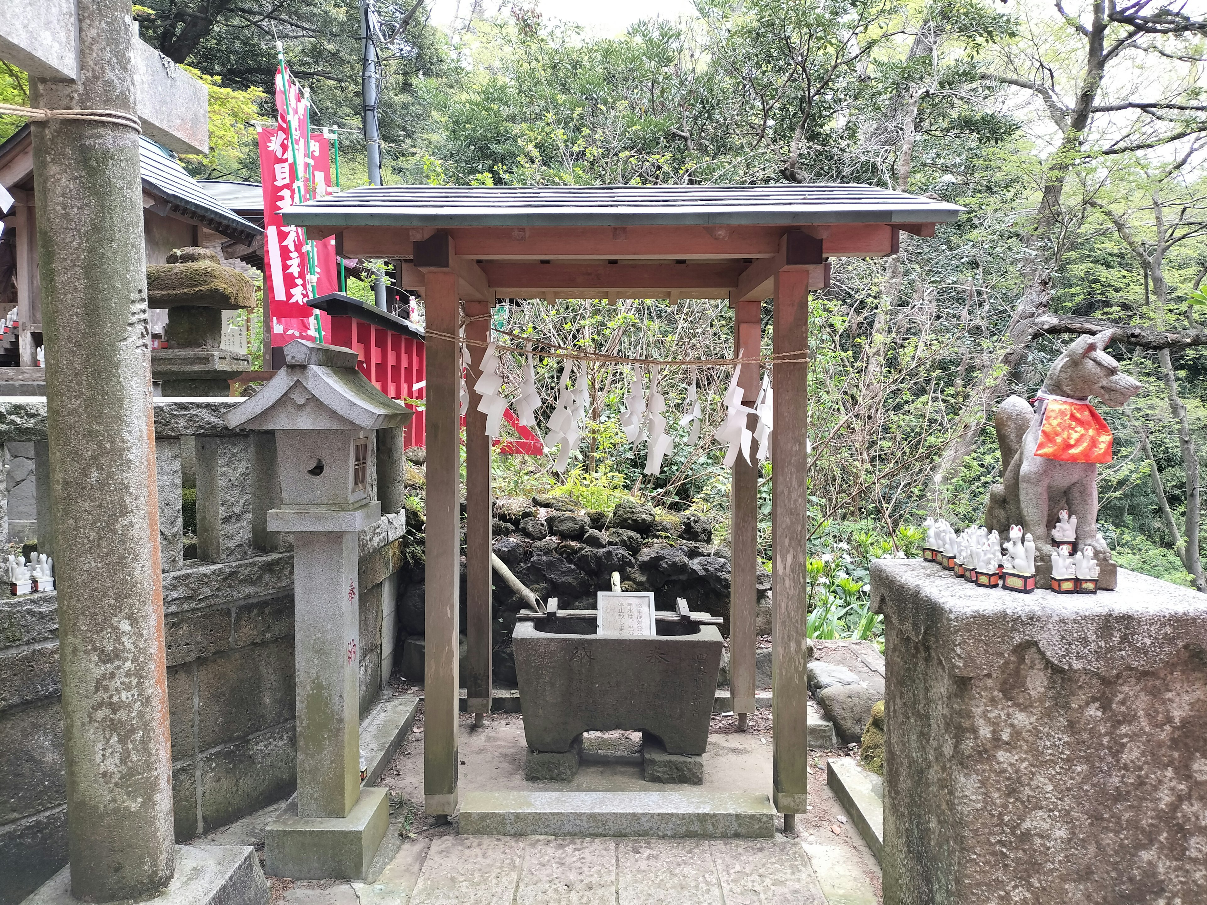 Vista de un santuario con área de purificación y estatua de piedra