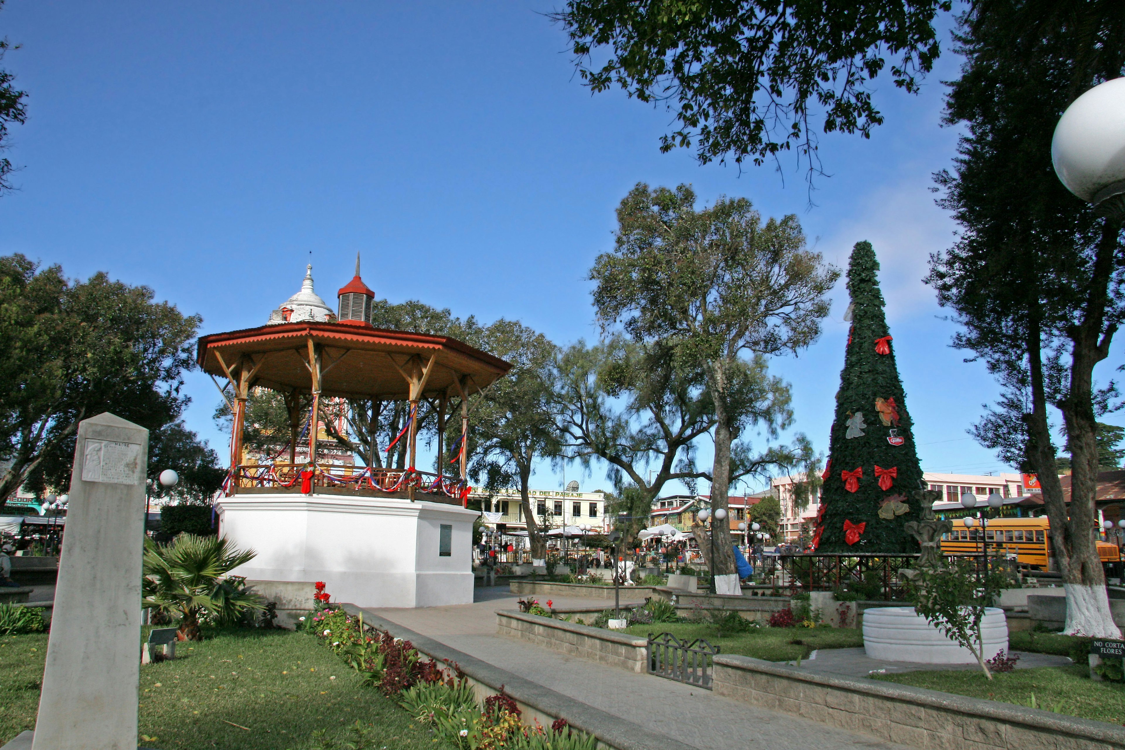 Pemandangan taman yang hidup dengan gazebo dan pohon Natal yang dihias