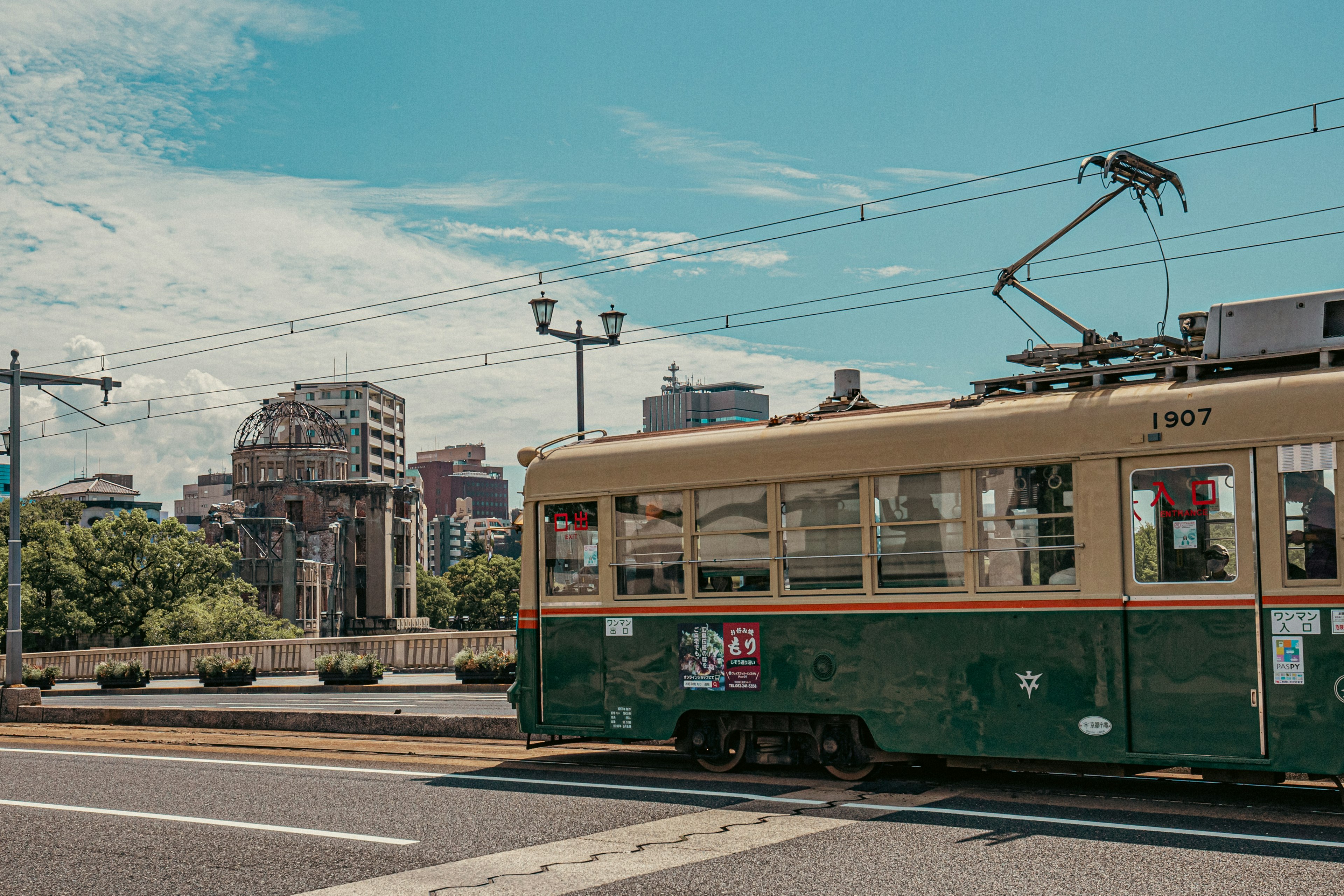 緑の路面電車が都市の背景を走る風景