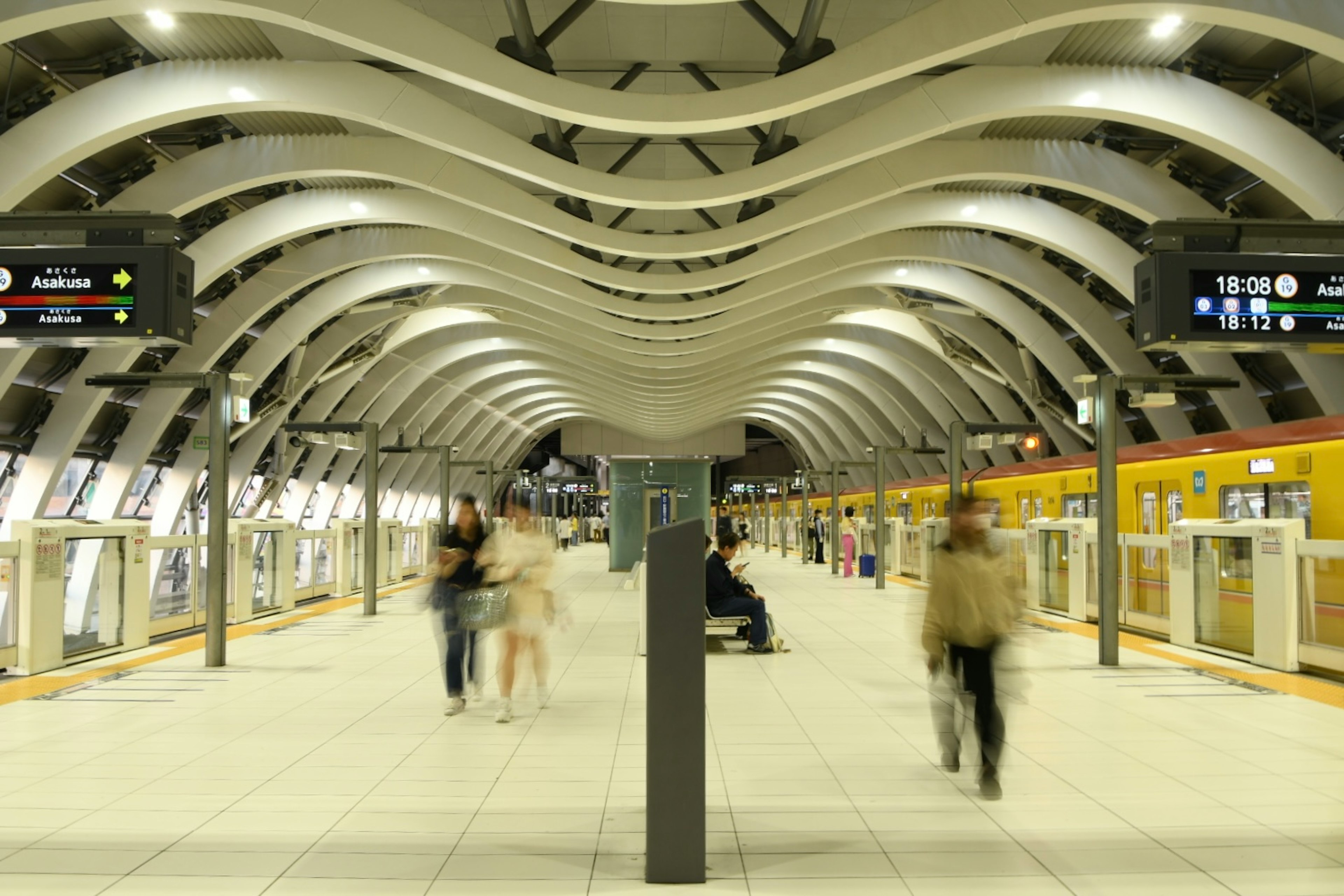 Innenansicht einer modernen U-Bahn-Station mit vorbeigehenden Menschen