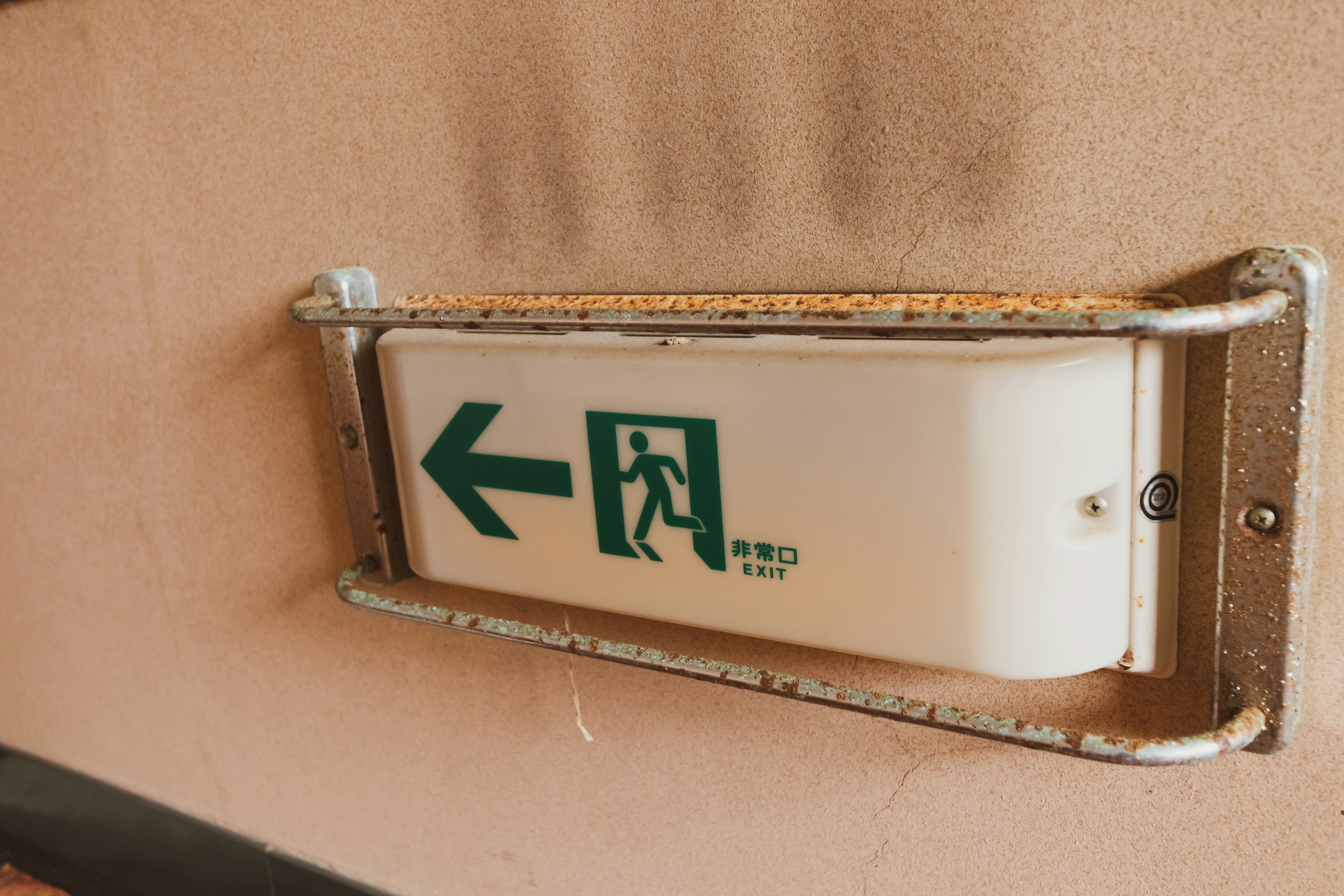 Exit sign featuring a green arrow and a person icon