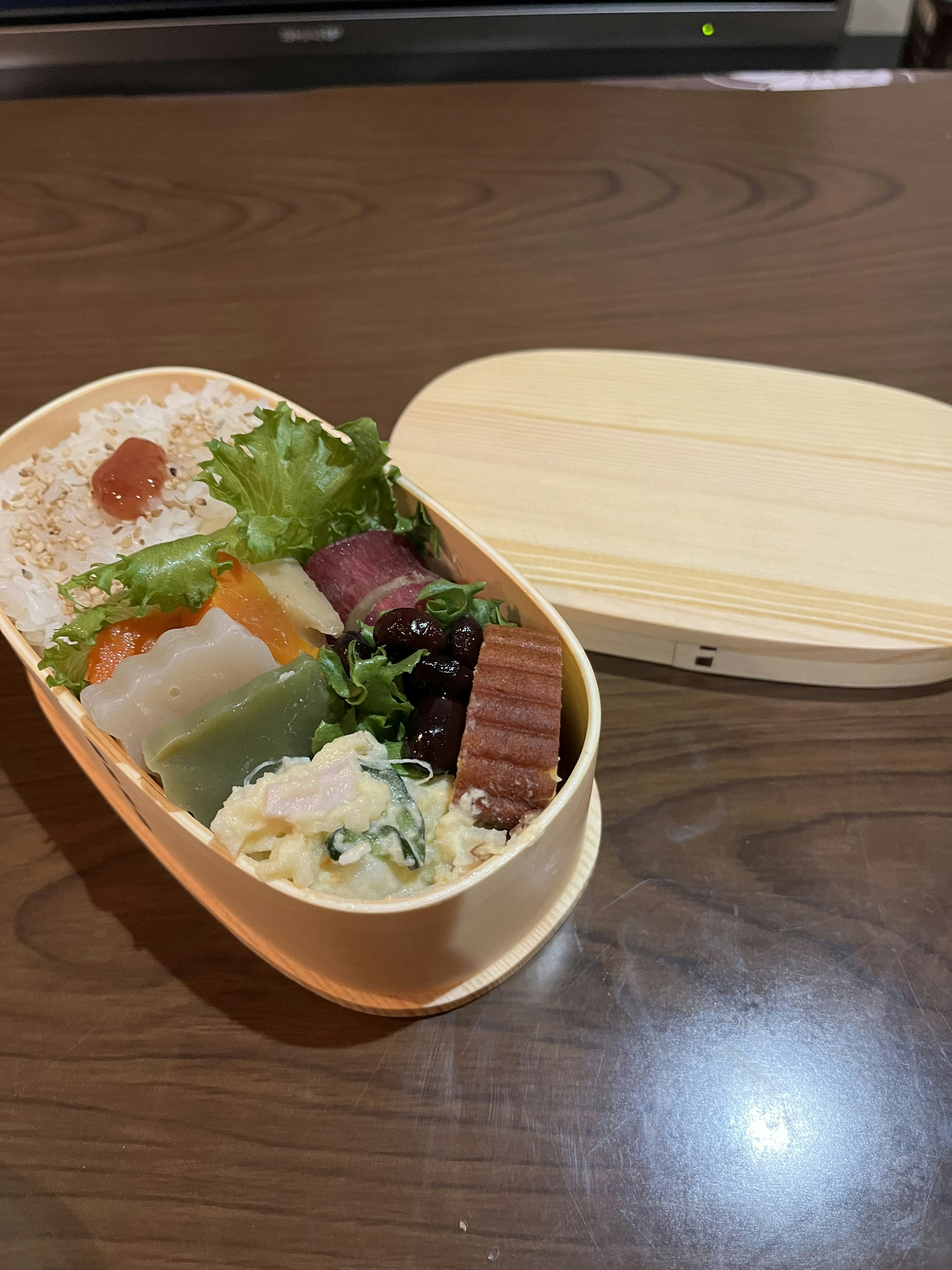 A colorful assortment of food in a bento box with rice