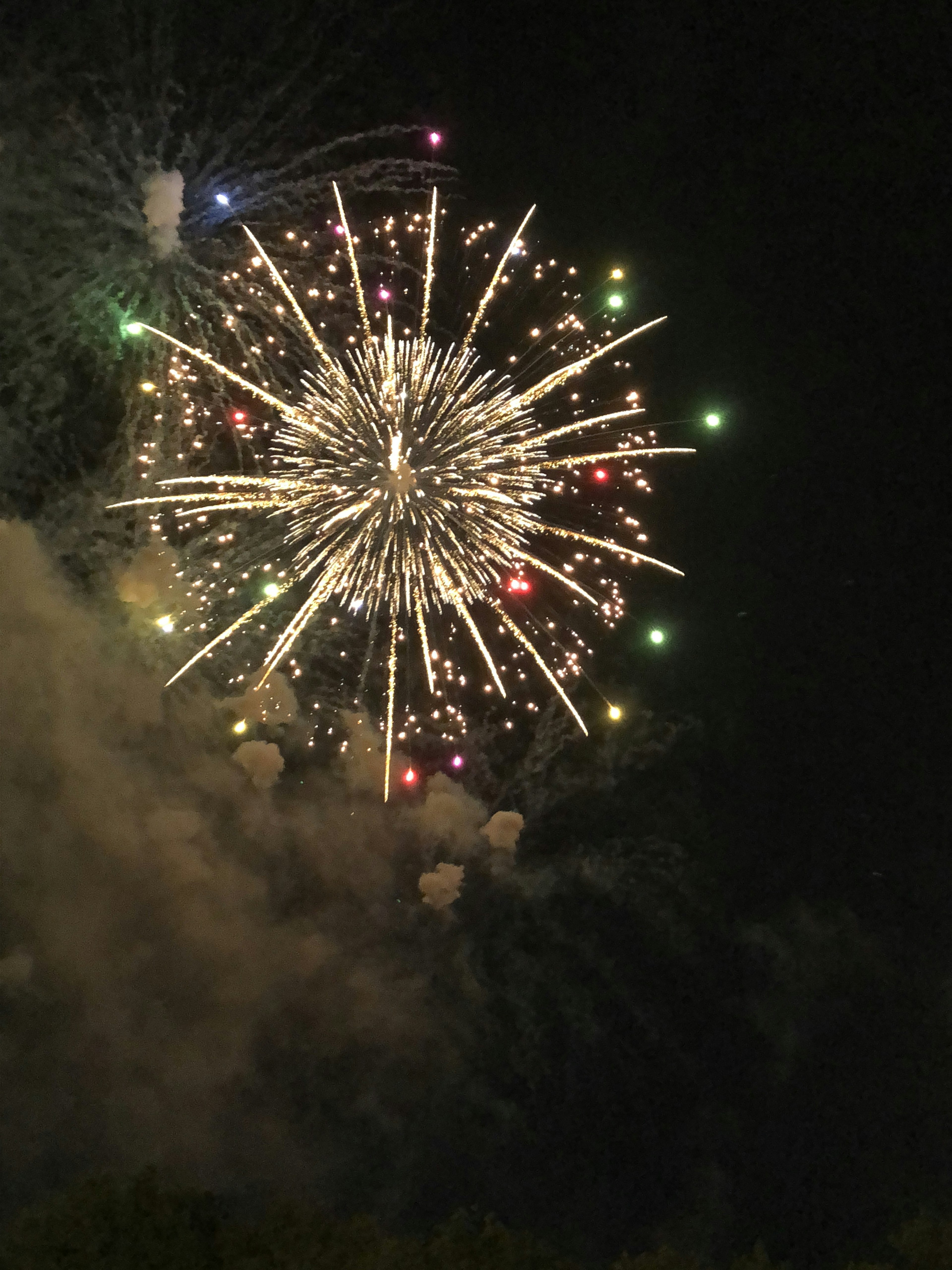 五彩缤纷的烟花在夜空中爆炸，伴随烟雾