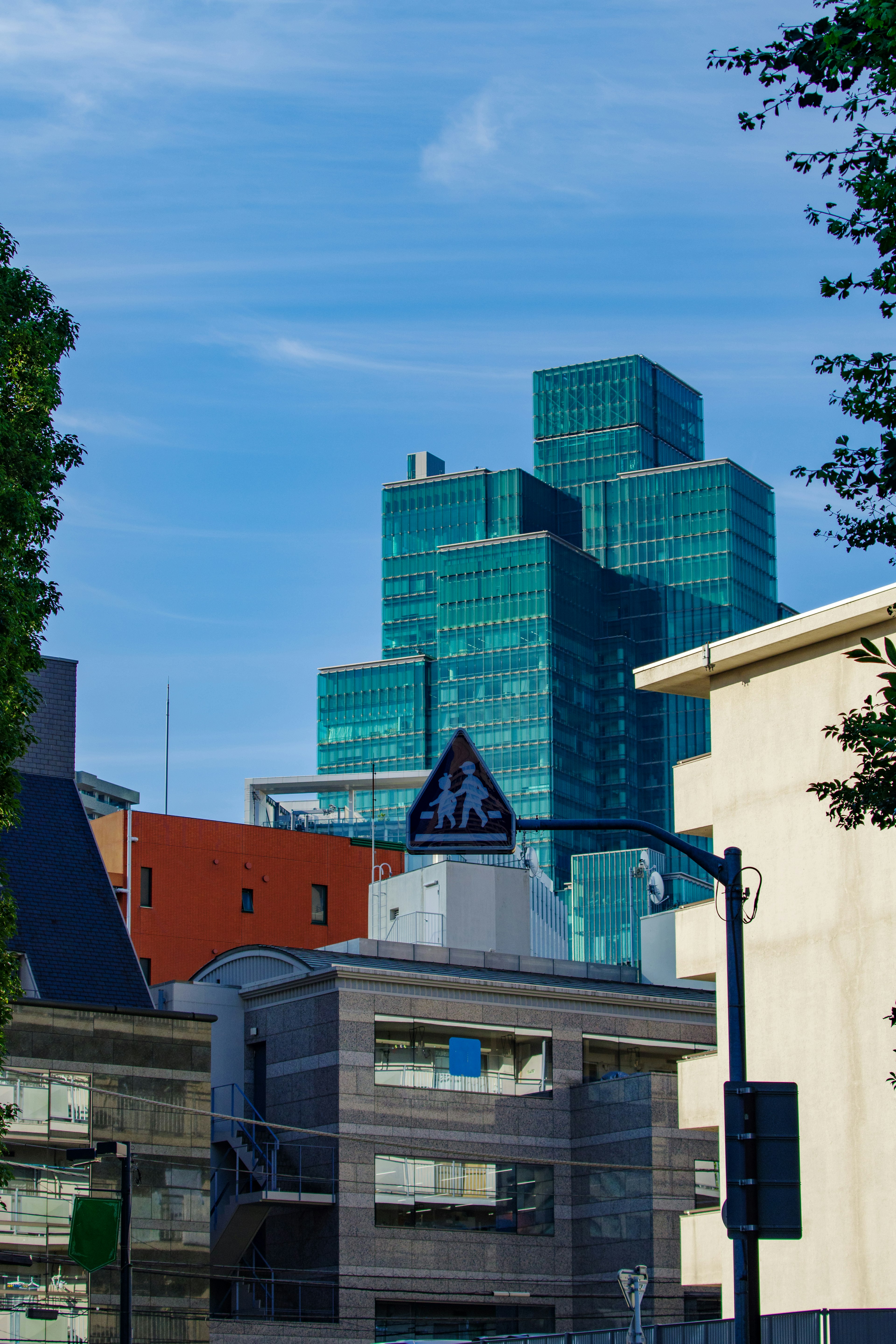 Gedung pencakar langit modern di bawah langit biru cerah dengan lingkungan perkotaan