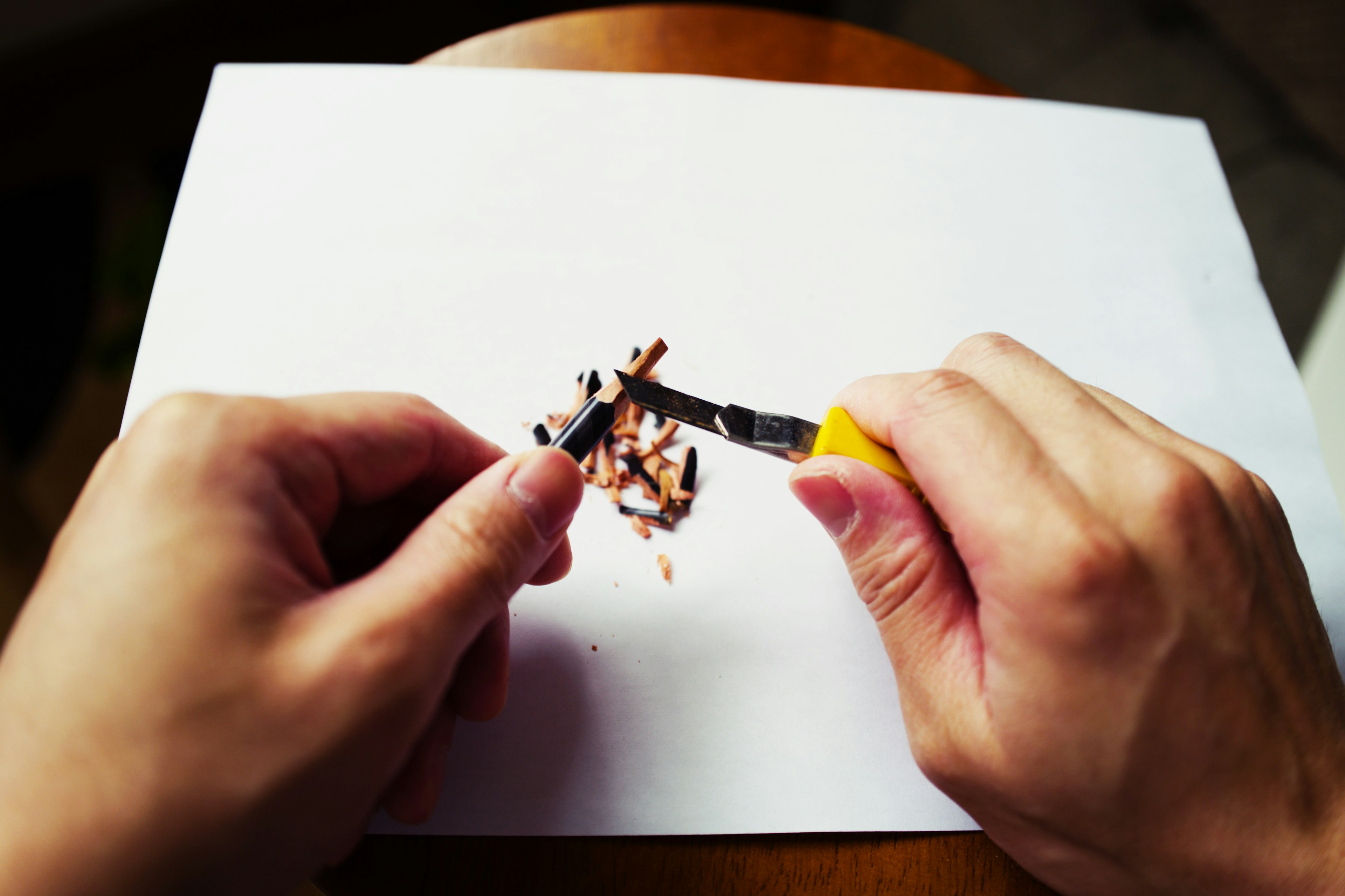 Hands using a cutter to cut paper