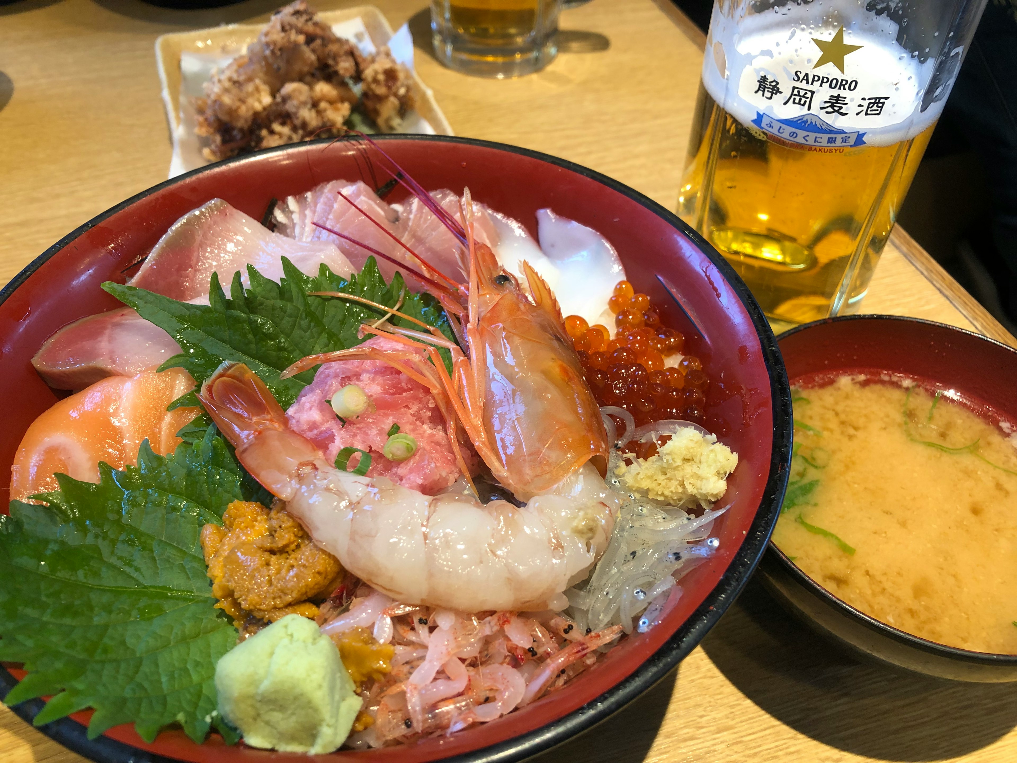 海鮮丼と味噌汁の美しい盛り付けビールが添えられた食事