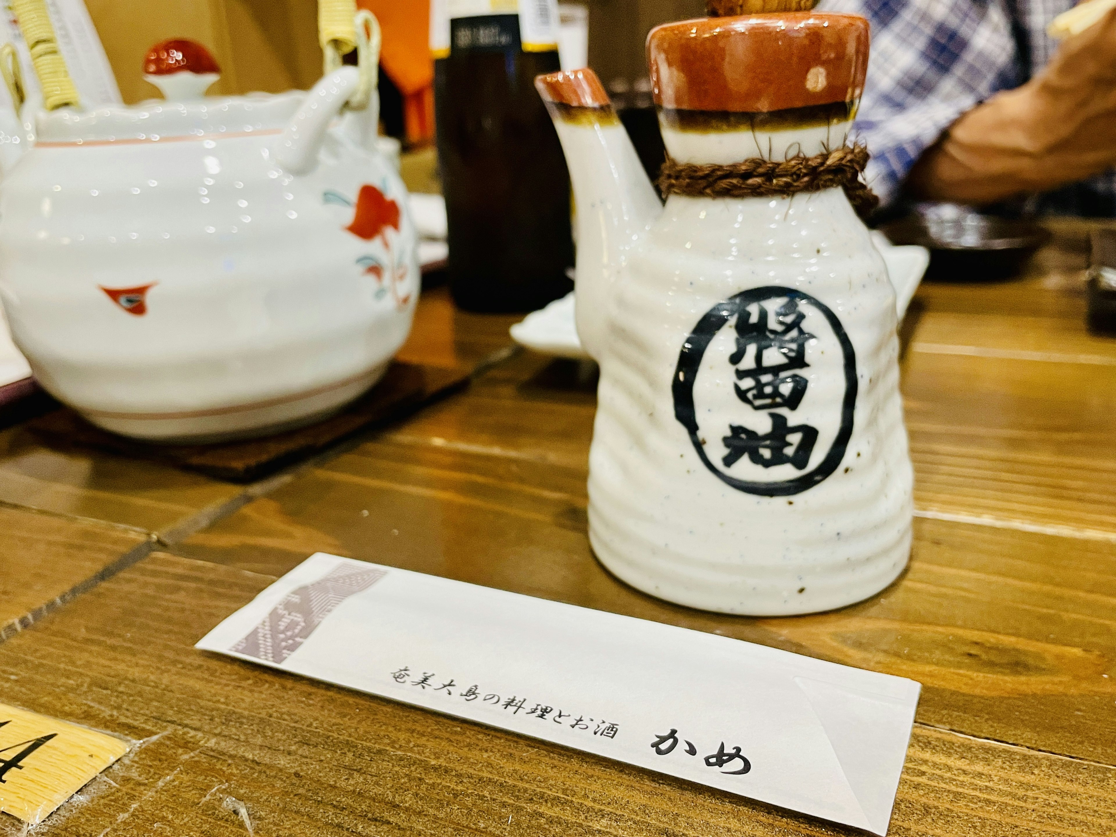 White ceramic soy sauce dispenser on a wooden table