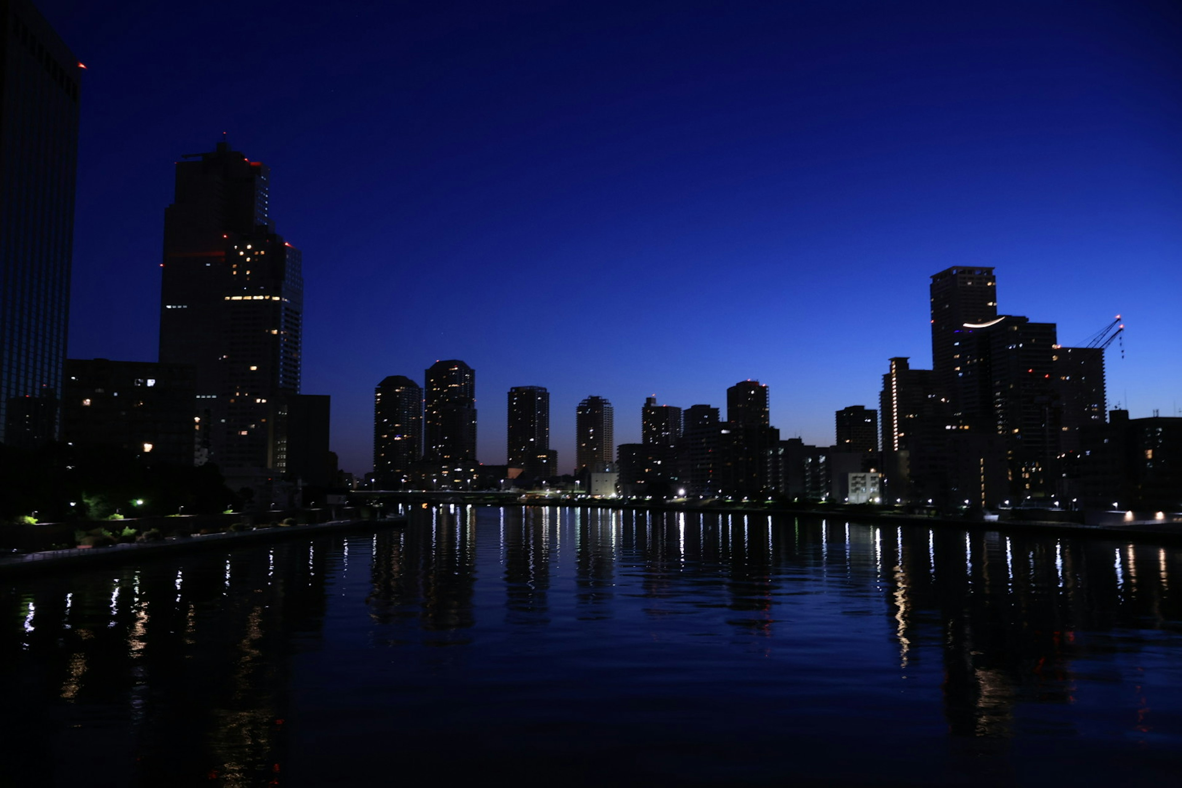 Night city skyline with reflections on water