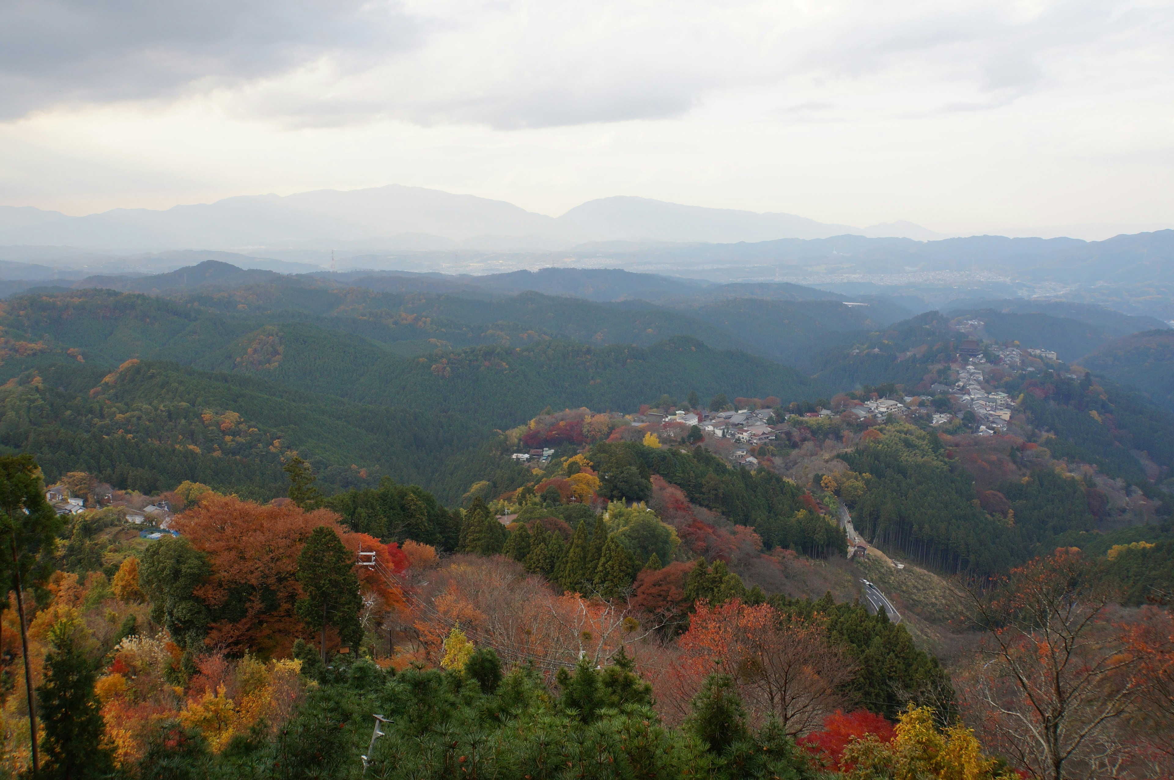 秋の彩りに包まれた山々の風景と曇り空